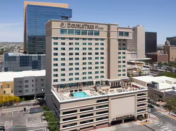 DoubleTree hotel exterior with a pool deck, in an urban setting.