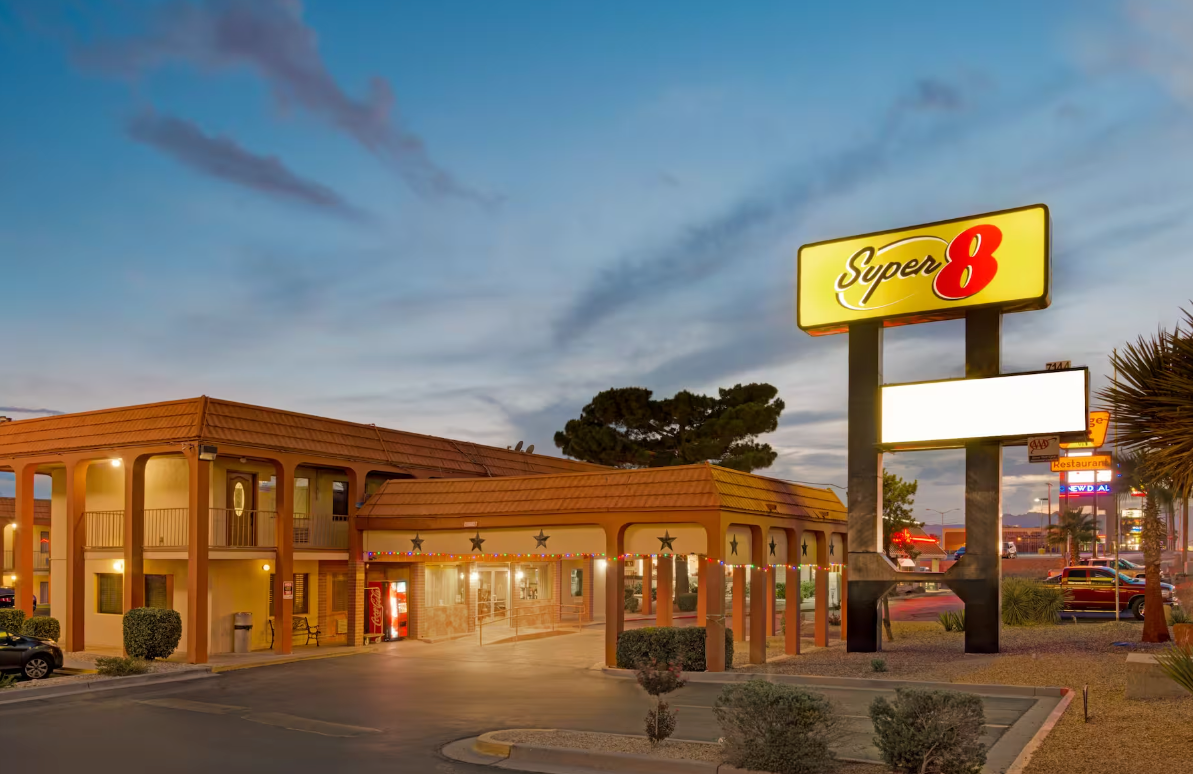 Super 8 motel at dusk with a lit sign and covered entrance.