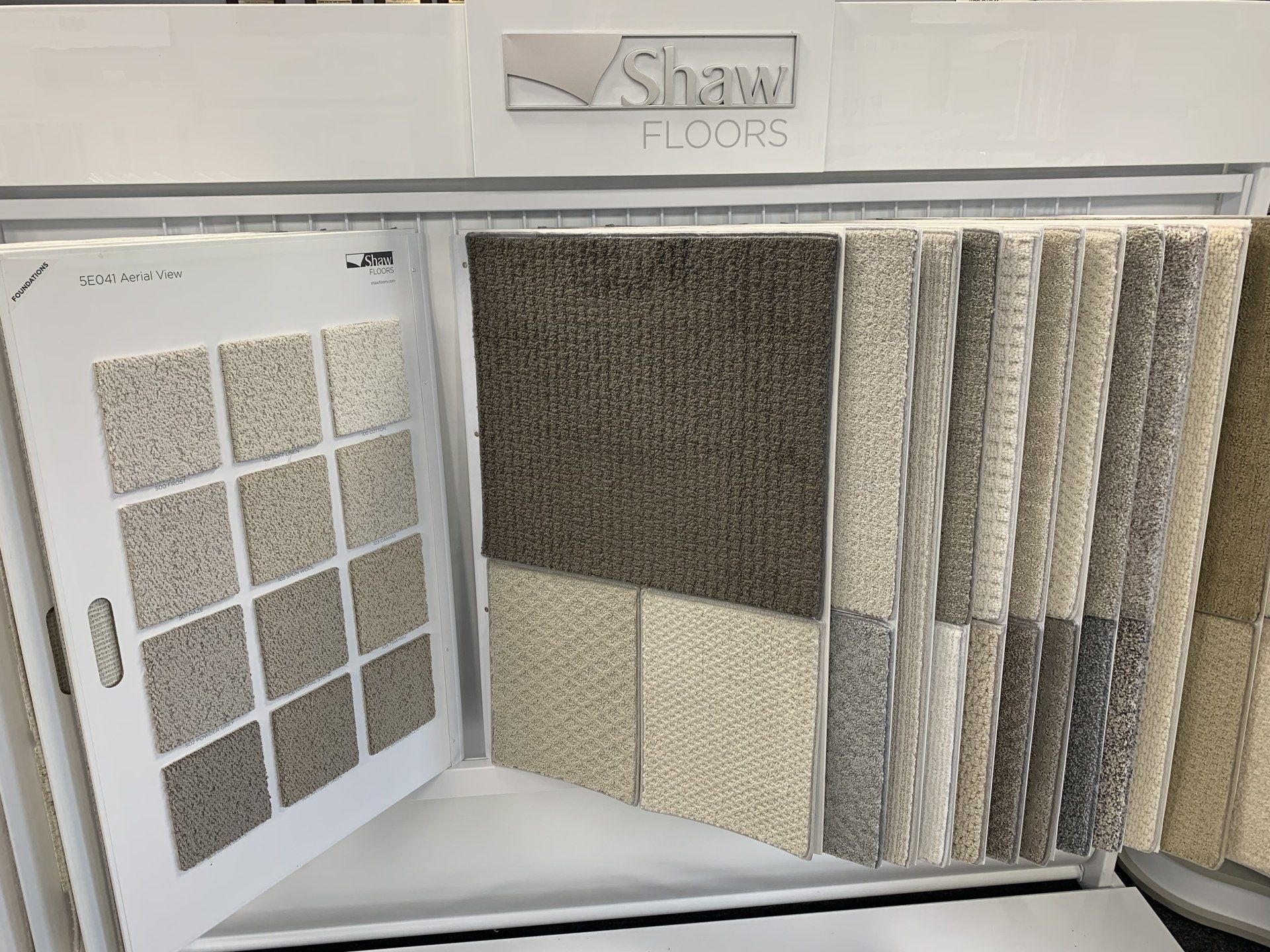 A display case filled with a variety of carpets and tiles.