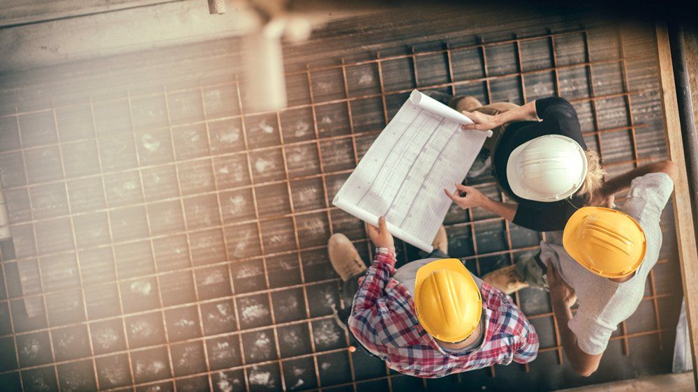 Men Looking At A Blueprint — Carlsbad, NM — ENM Construction Management Ltd