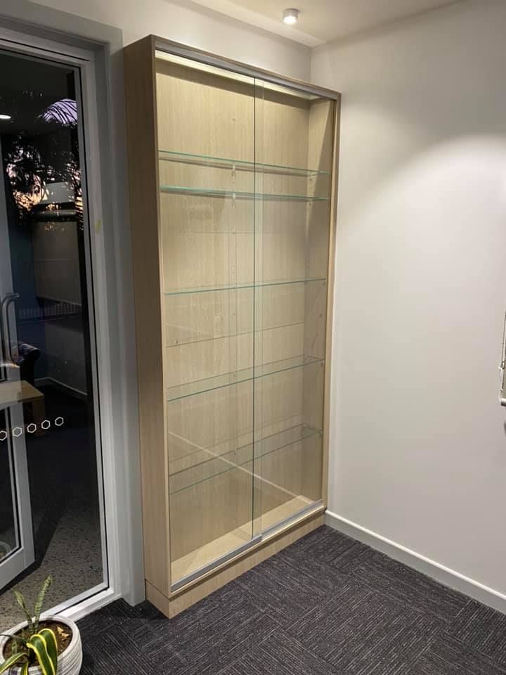 A Glass Display Case Is Sitting In A Room Next To A Door — O'Donnell Cabinetmaking in Kawana, QLD