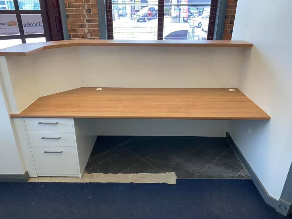 A Wooden Desk With Drawers Underneath It In A Room With A Window — O'Donnell Cabinetmaking in Kawana, QLD
