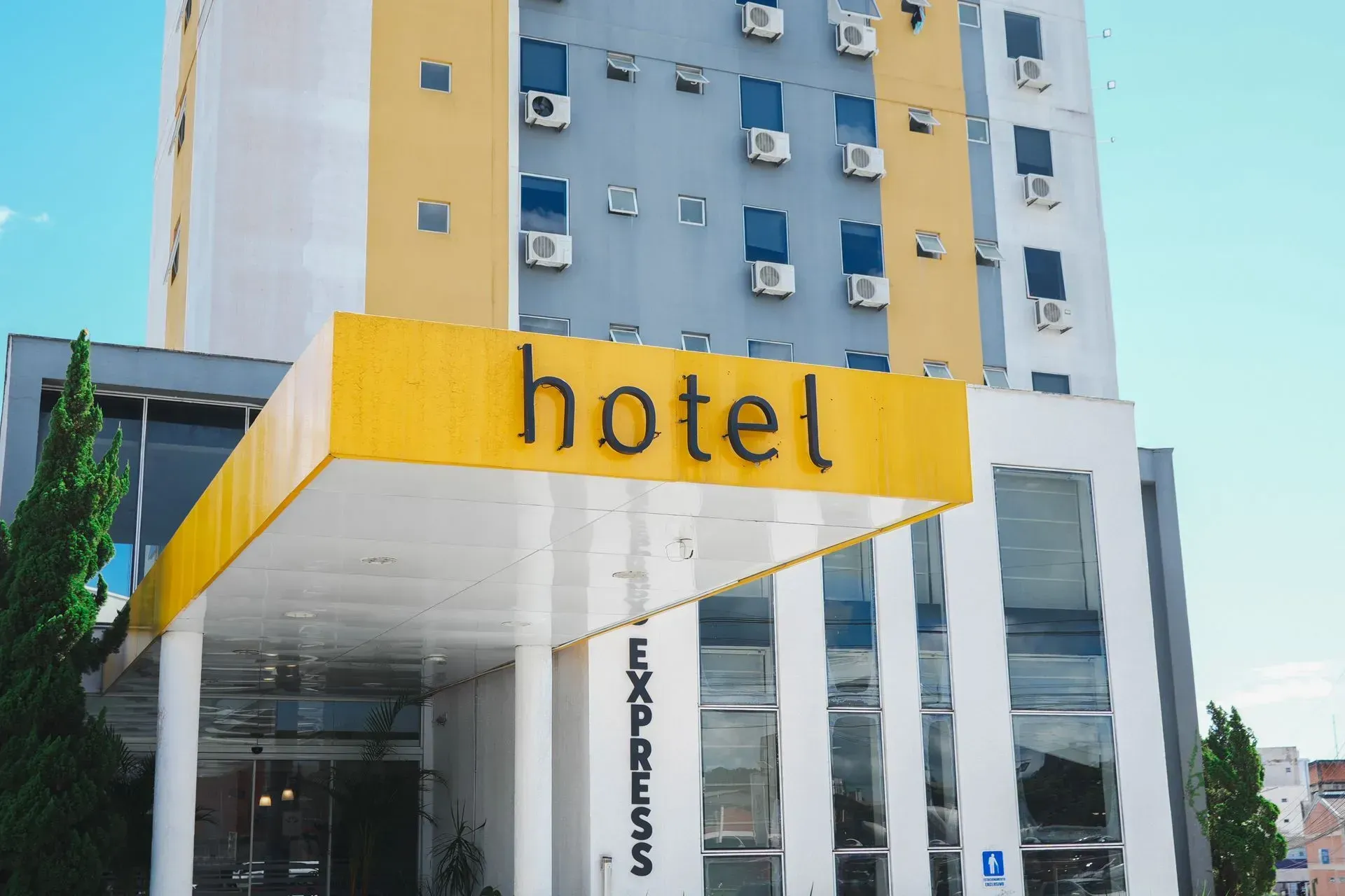 A frente de um hotel com um toldo amarelo sobre a entrada.