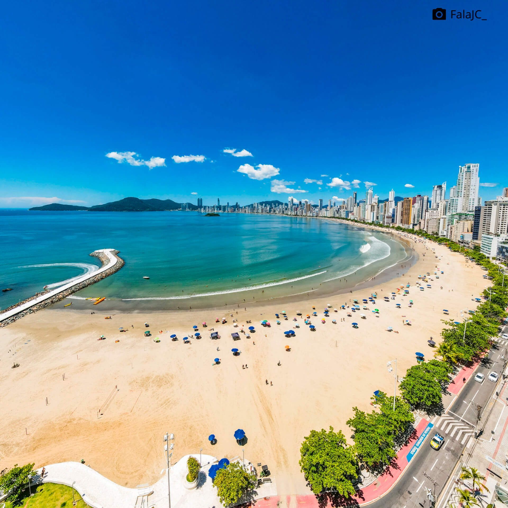 Uma vista aérea de uma praia com uma cidade ao fundo
