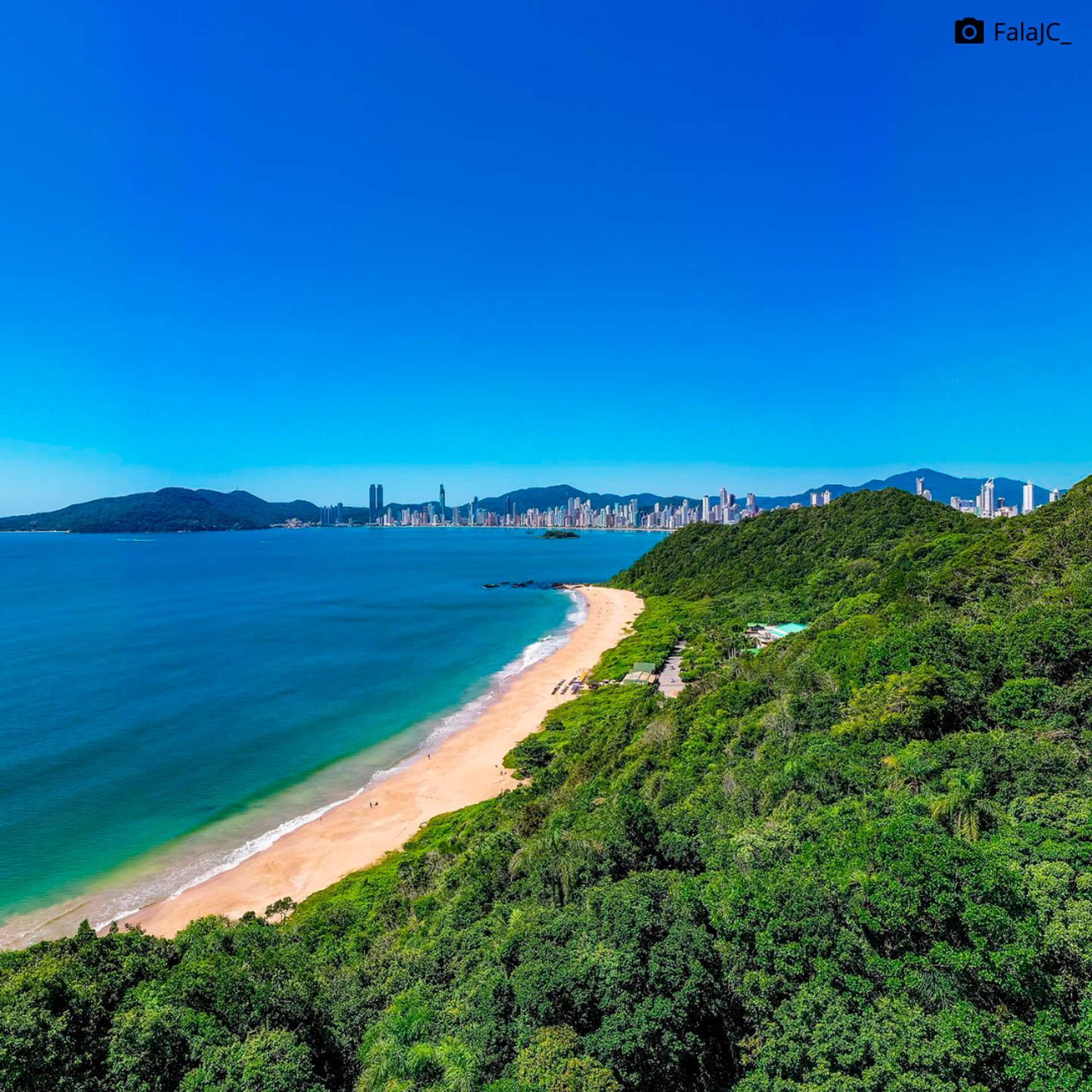 Uma vista aérea de uma praia com uma cidade ao fundo