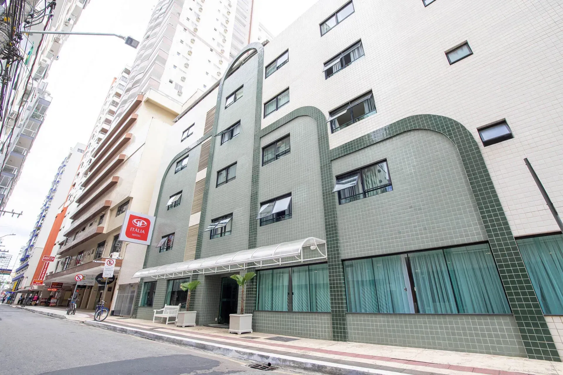 Um grande edifício com muitas janelas está situado na lateral de uma rua da cidade.