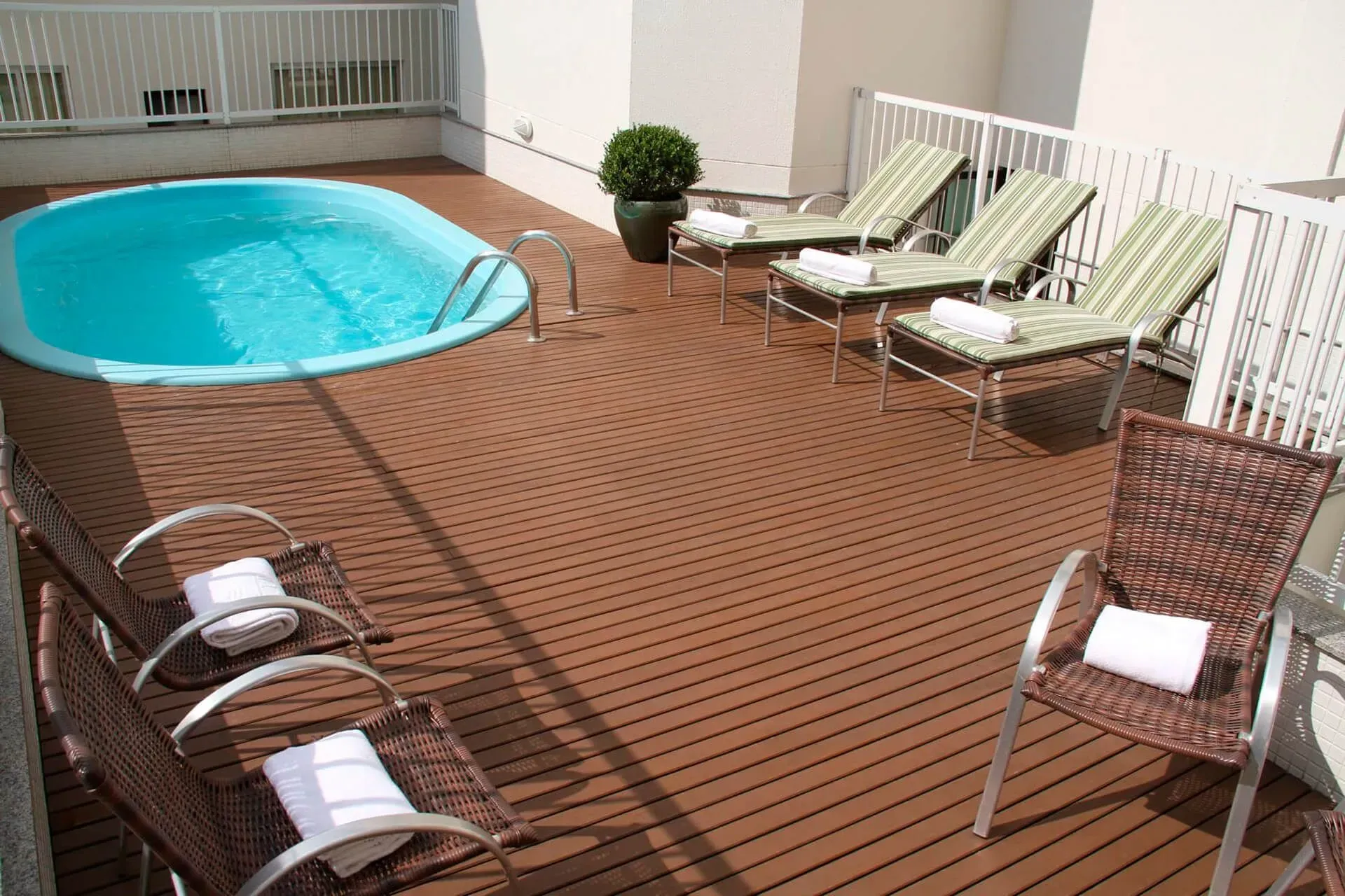 Um deck com cadeiras e uma piscina