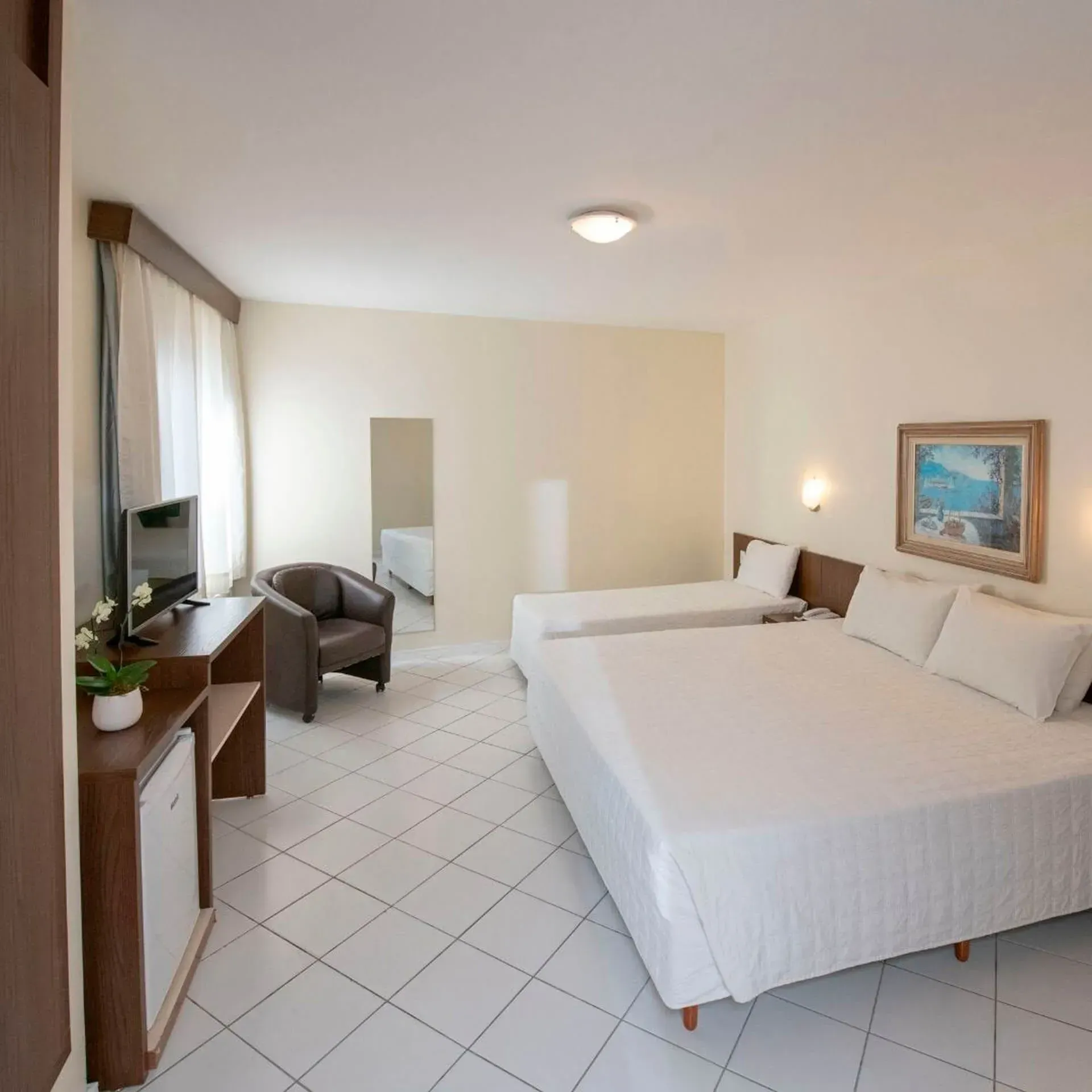 Um quarto de hotel com duas camas e uma cadeira