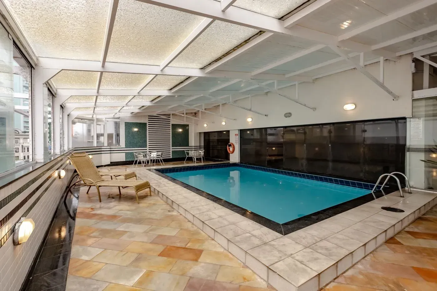 Há uma grande piscina coberta no meio da sala.