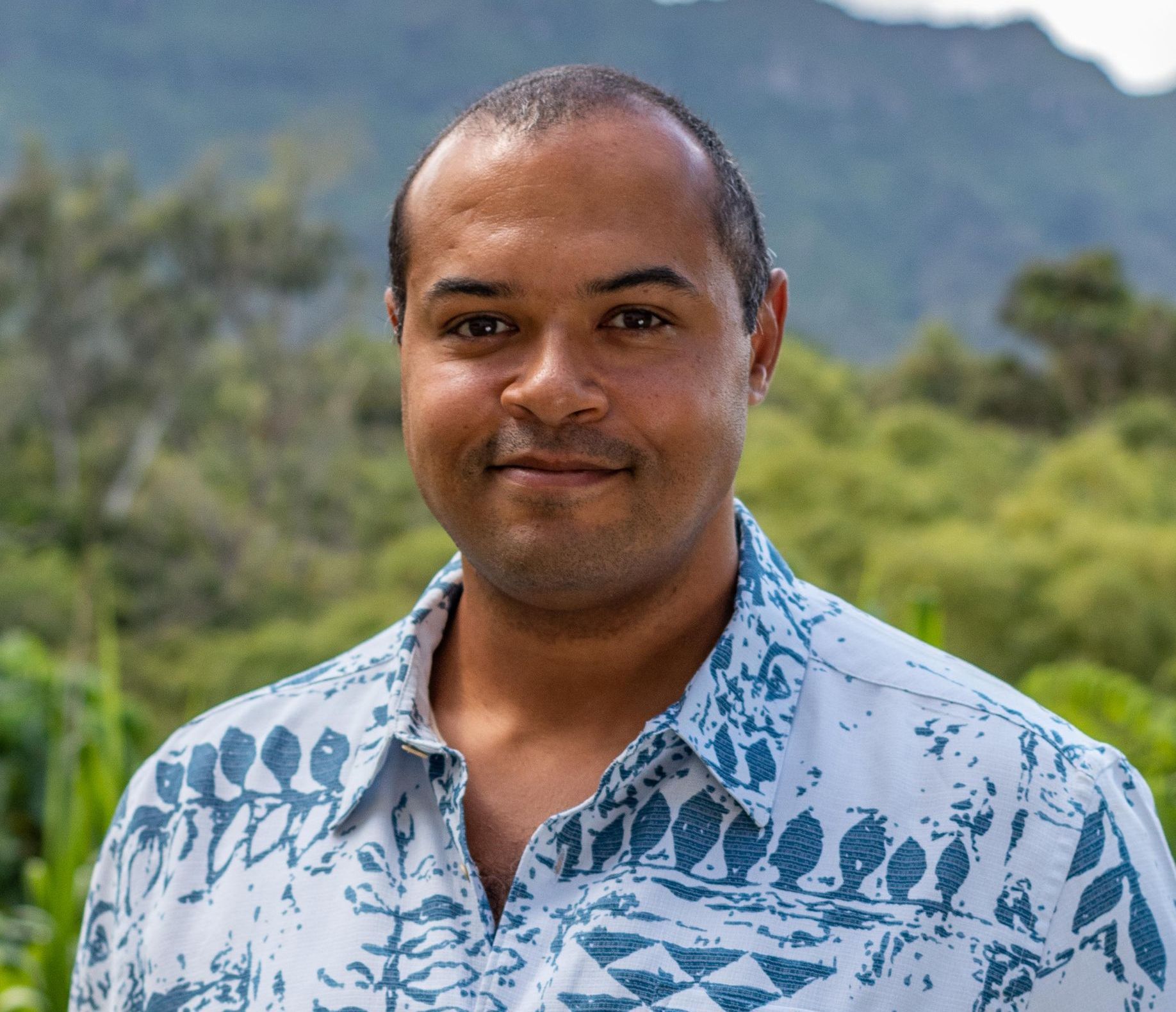 A man in a suit and white shirt is smiling for the camera.