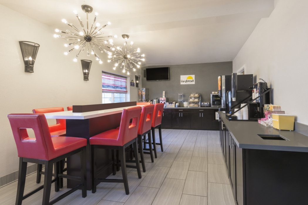 Breakfast area with high-top seating and red chairs. Includes a buffet and coffee station.