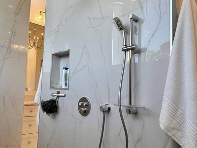 A bathroom with a shower and a towel hanging on the wall.