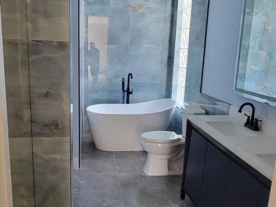 A bathroom with a tub , toilet , sink and shower.