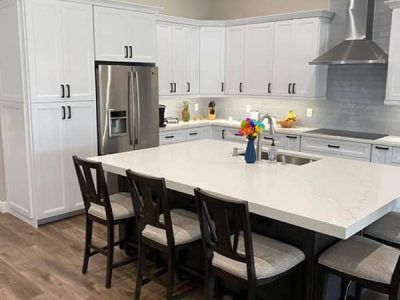 A kitchen with white cabinets and stainless steel appliances and a large island.