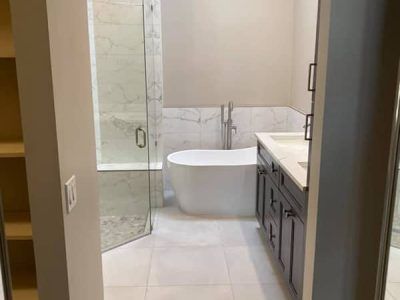 A bathroom with a tub , sink , and shower.