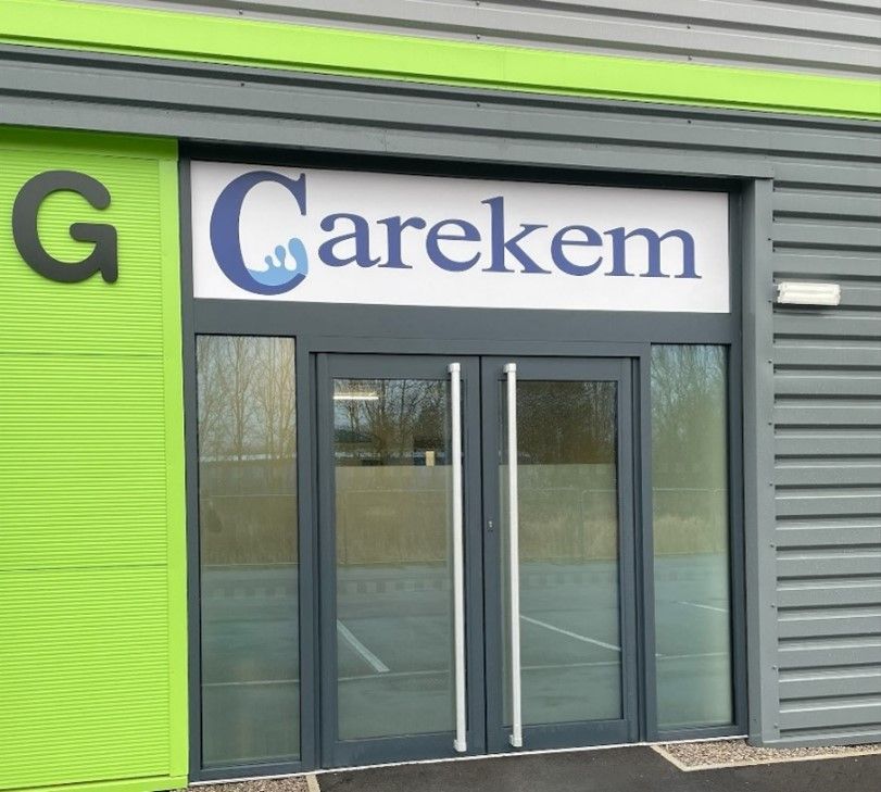 A green building with a sign that says Carekem