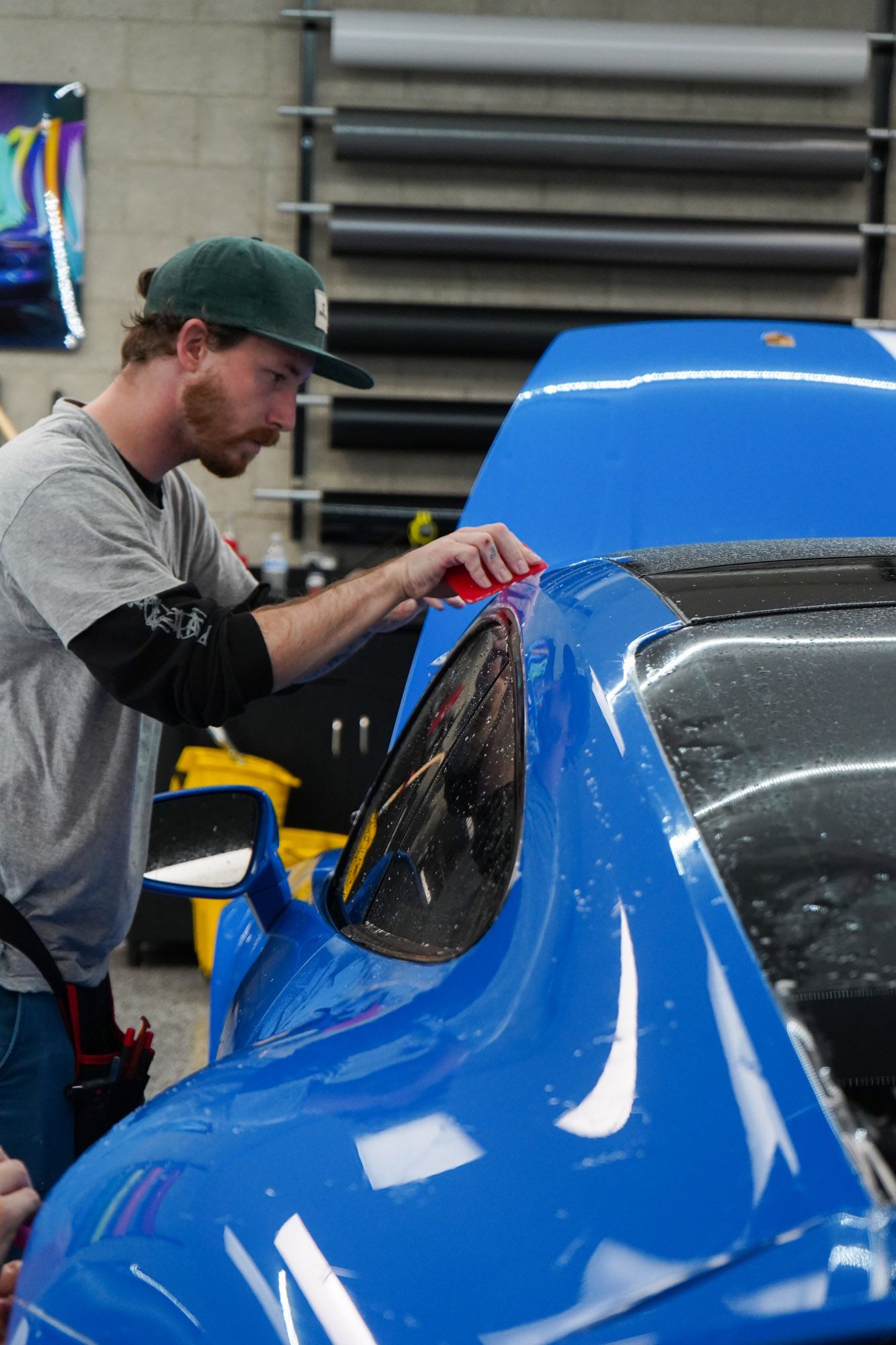 A close up of an orange lamborghini urus parked in a garage.