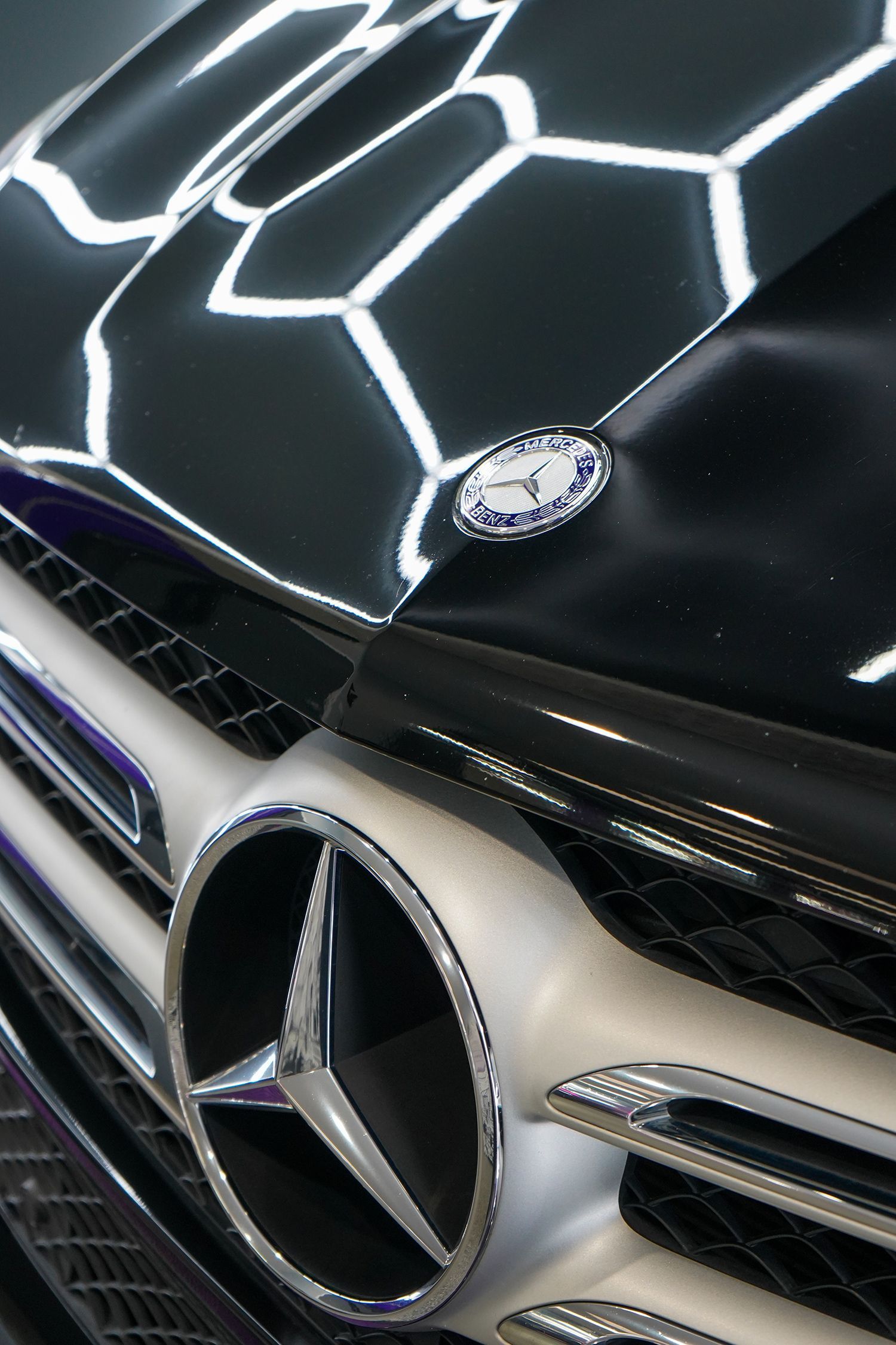 A close up of an orange lamborghini urus parked in a garage.
