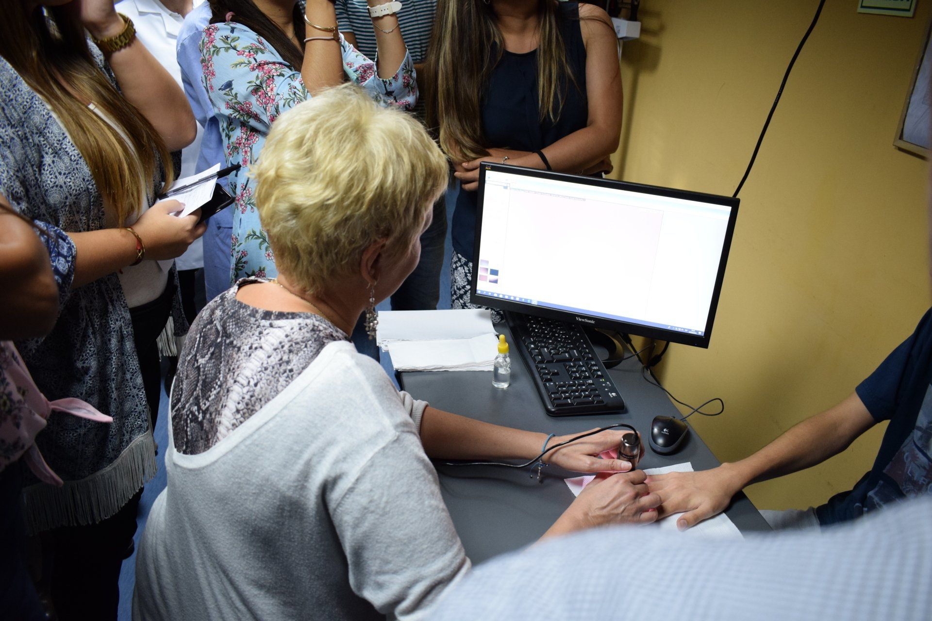 Una mujer está sentada en un escritorio frente a una computadora.
