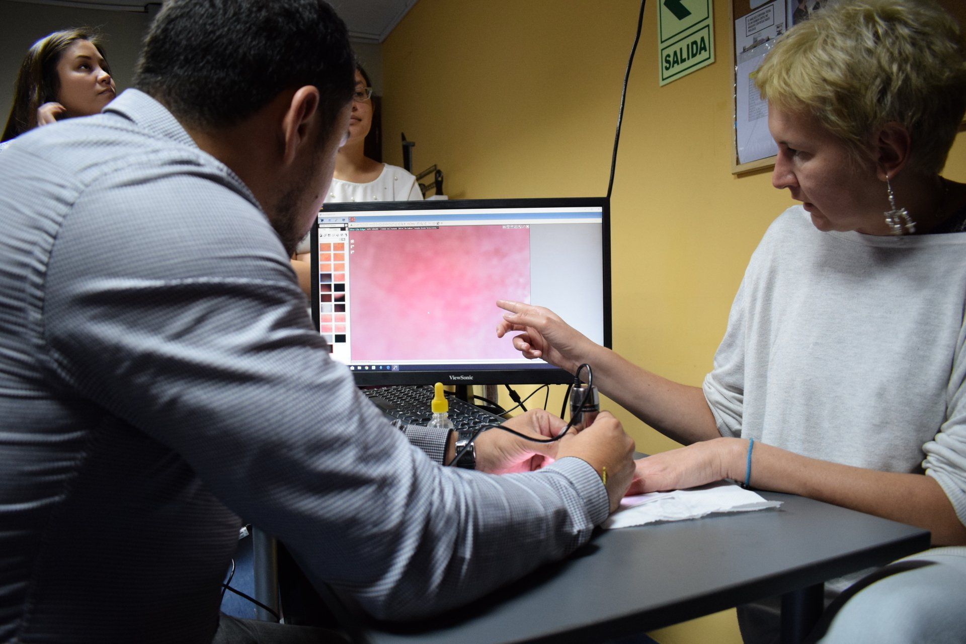 Un hombre y una mujer están mirando una pantalla de computadora.