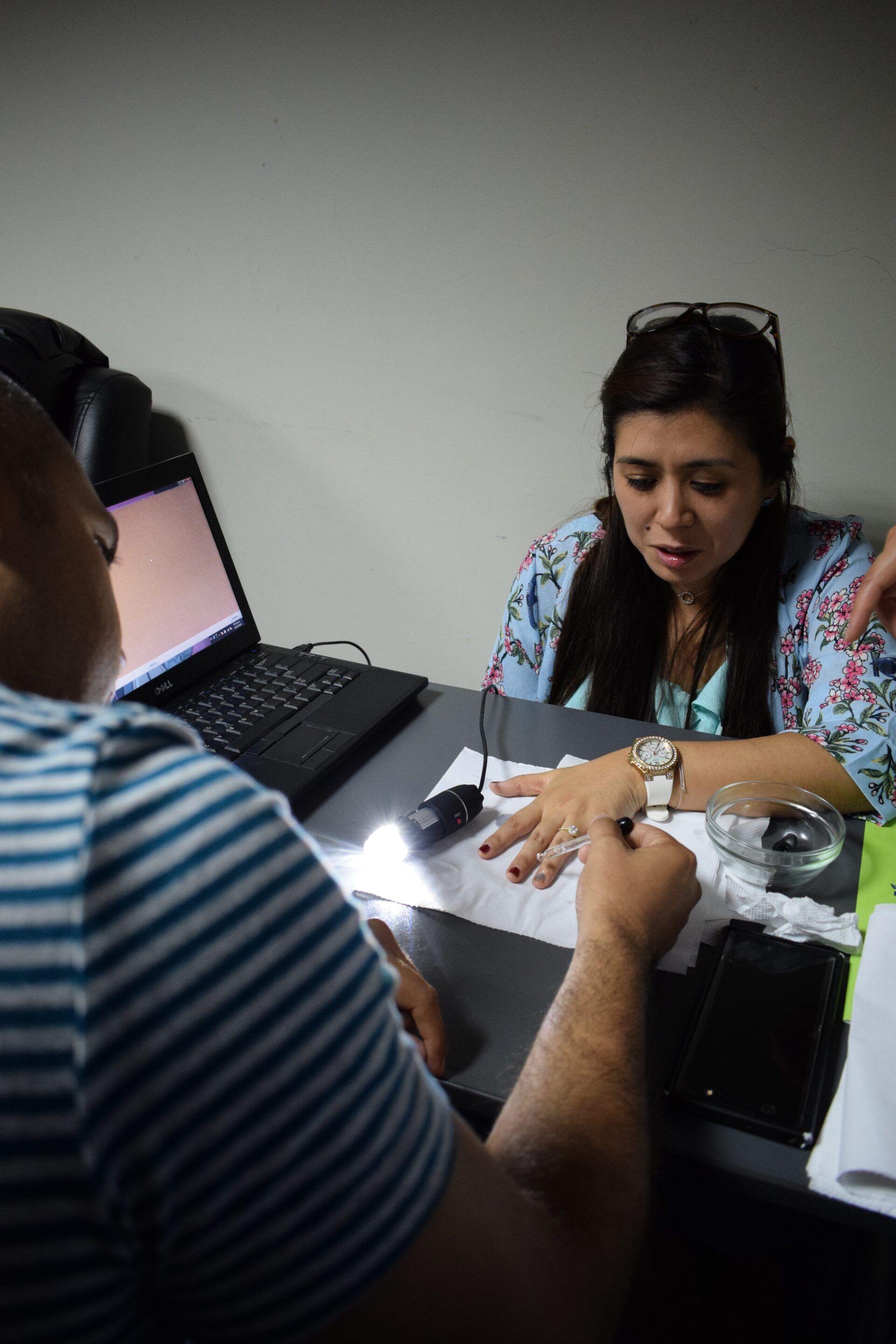 Un hombre y una mujer están sentados en una mesa con una computadora portátil.