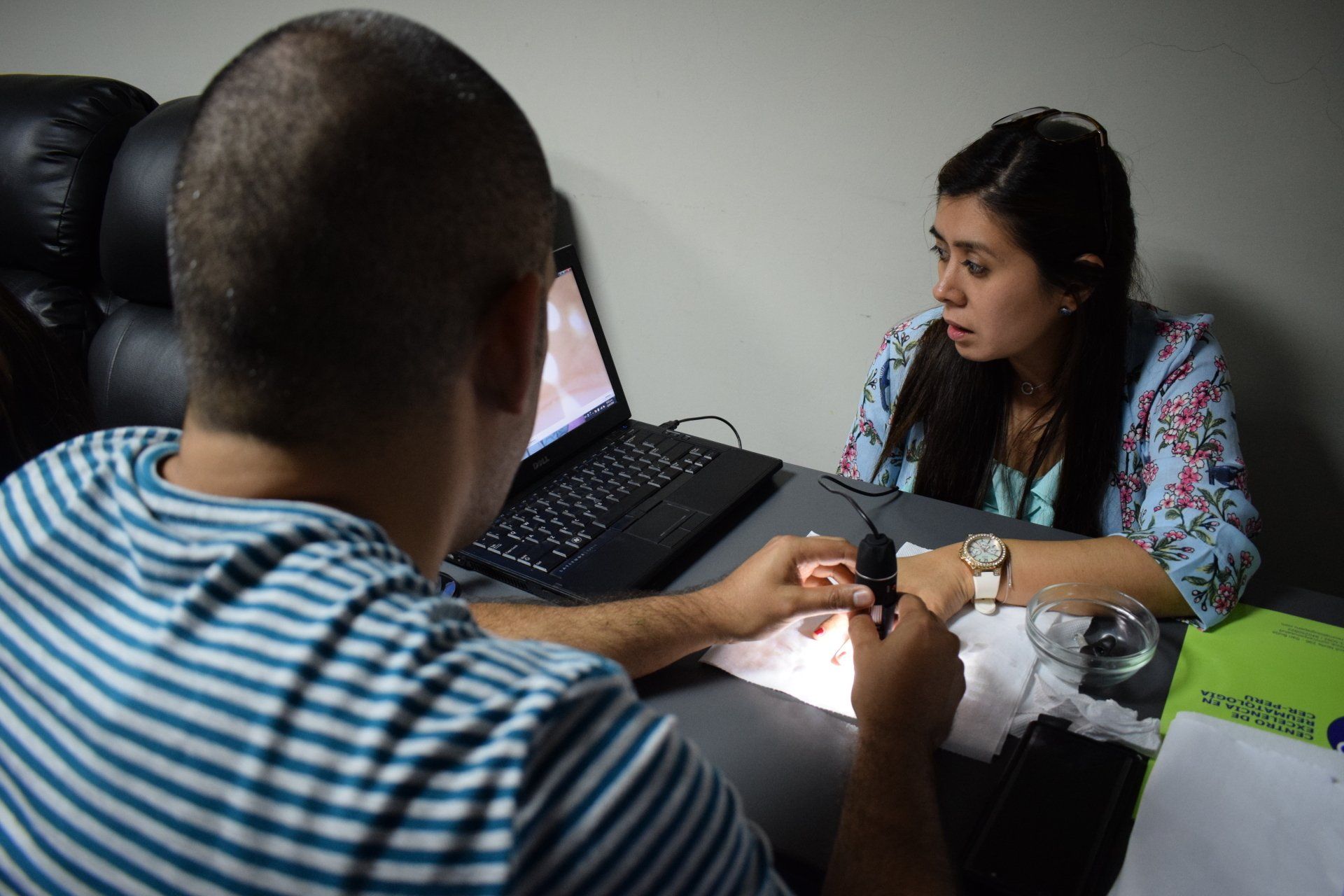 Un hombre y una mujer están sentados en una mesa con una computadora portátil.
