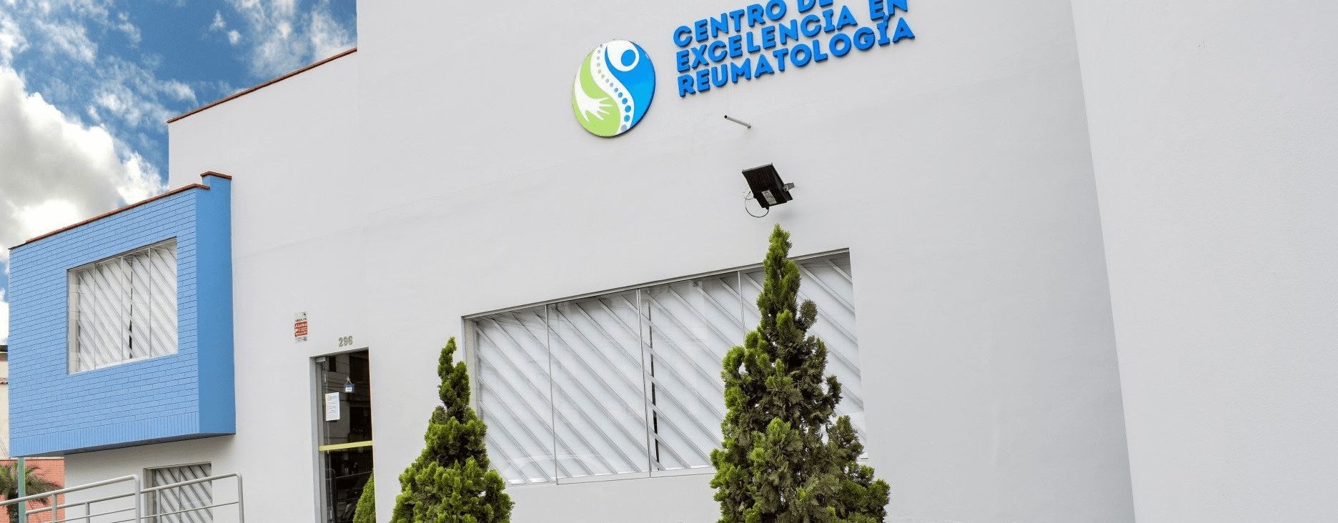 Un edificio blanco con dos árboles delante.