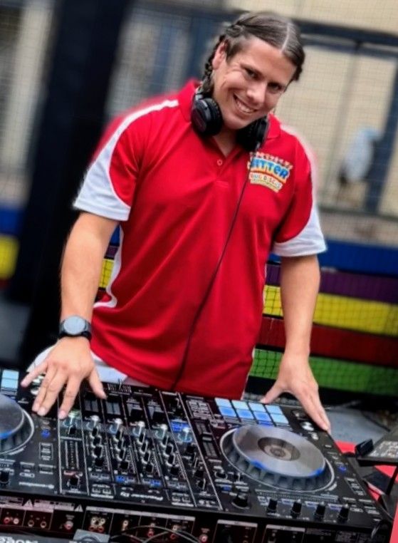 A silhouette of a dj wearing headphones playing music