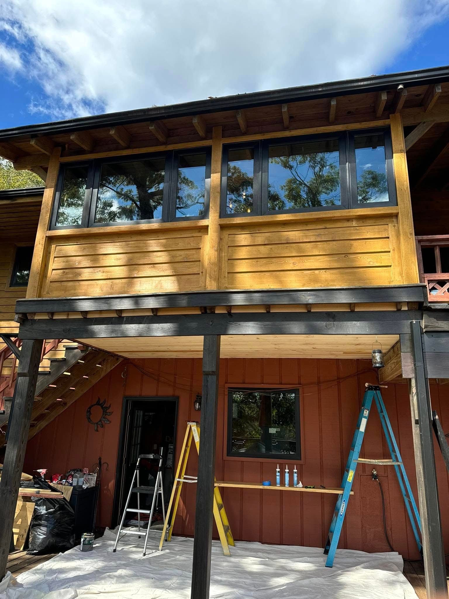 A wooden house with a balcony and stairs under construction.
