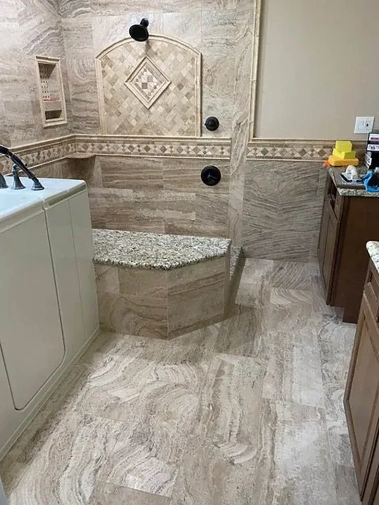 A bathroom with a walk in shower and a sink.