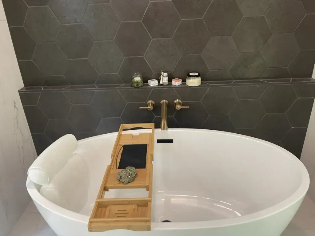 A bathtub with a wooden tray on it in a bathroom.