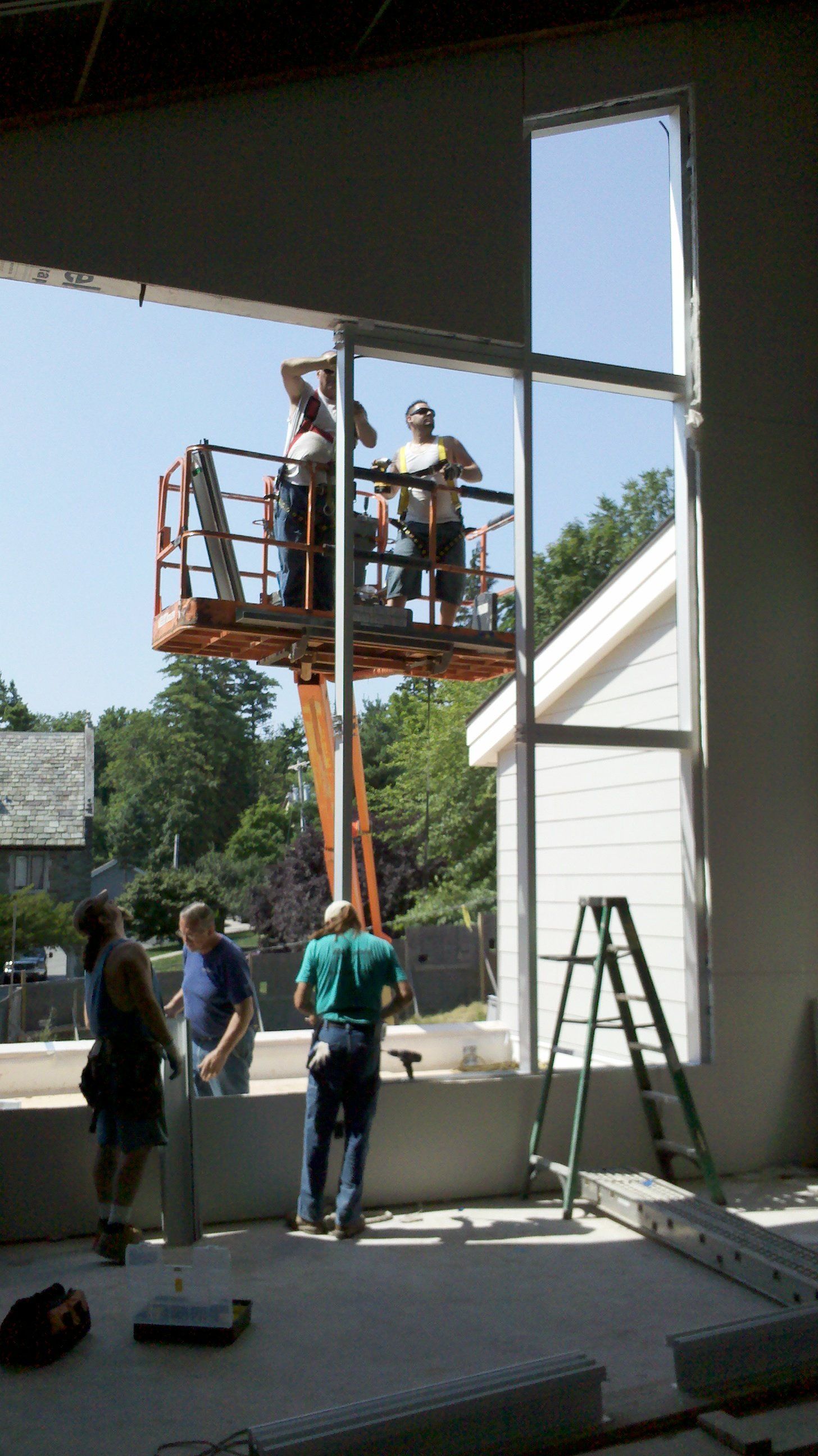 A group of construction workers are working on a large window.