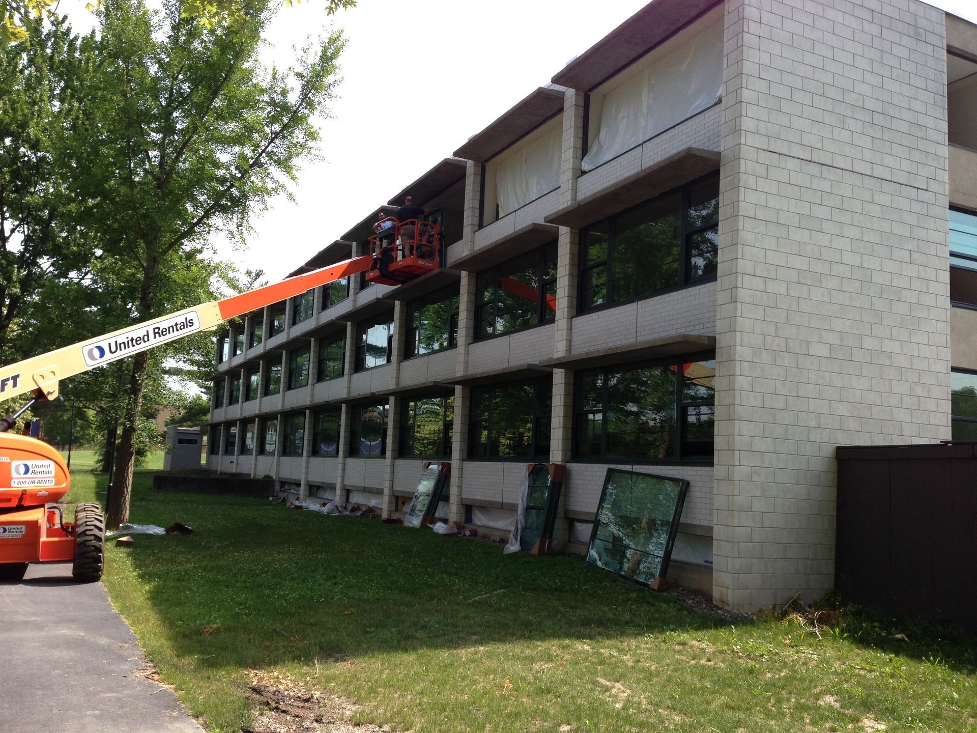 A large building with a jlg lift in front of it