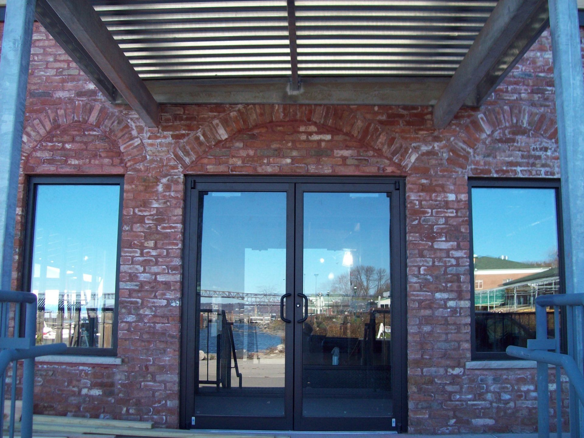 A brick building with a covered porch and glass doors