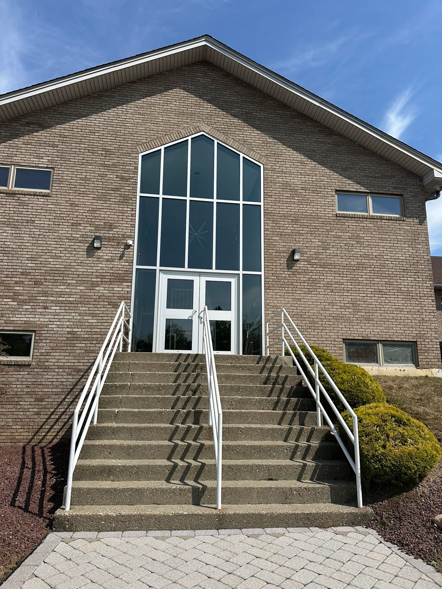 A brick building with stairs leading up to the front door.