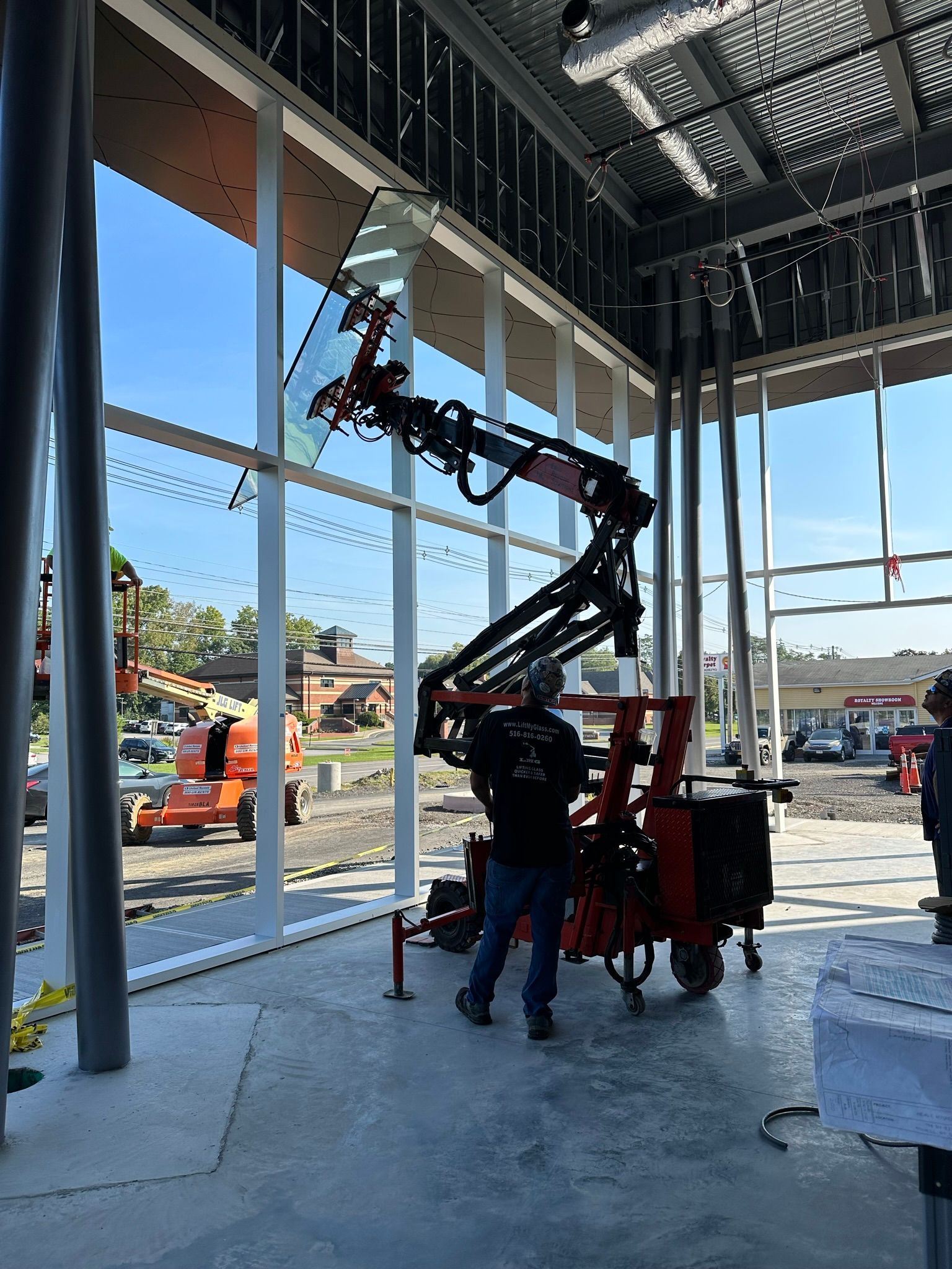 A man is standing next to a crane in a building under construction.