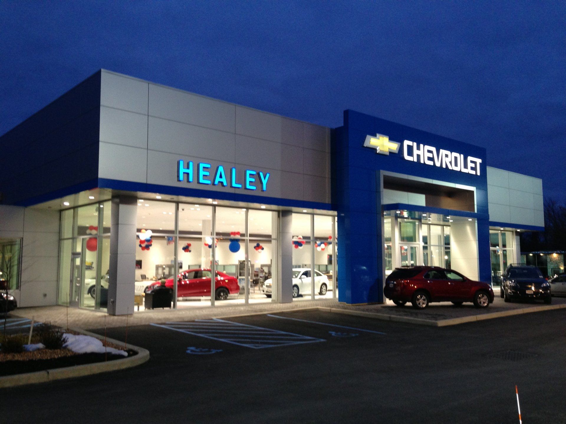 A chevrolet dealership with cars parked in front of it