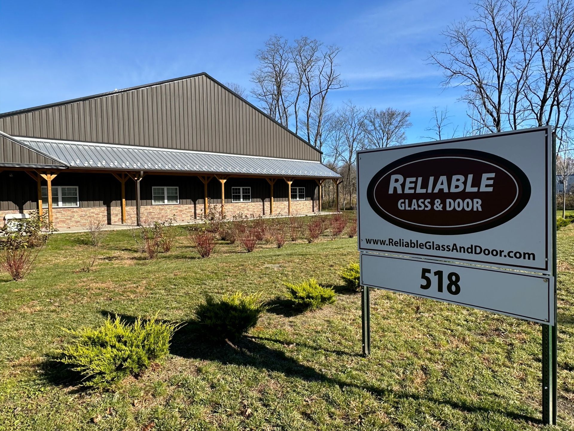 A man is standing in front of a glass revolving door.