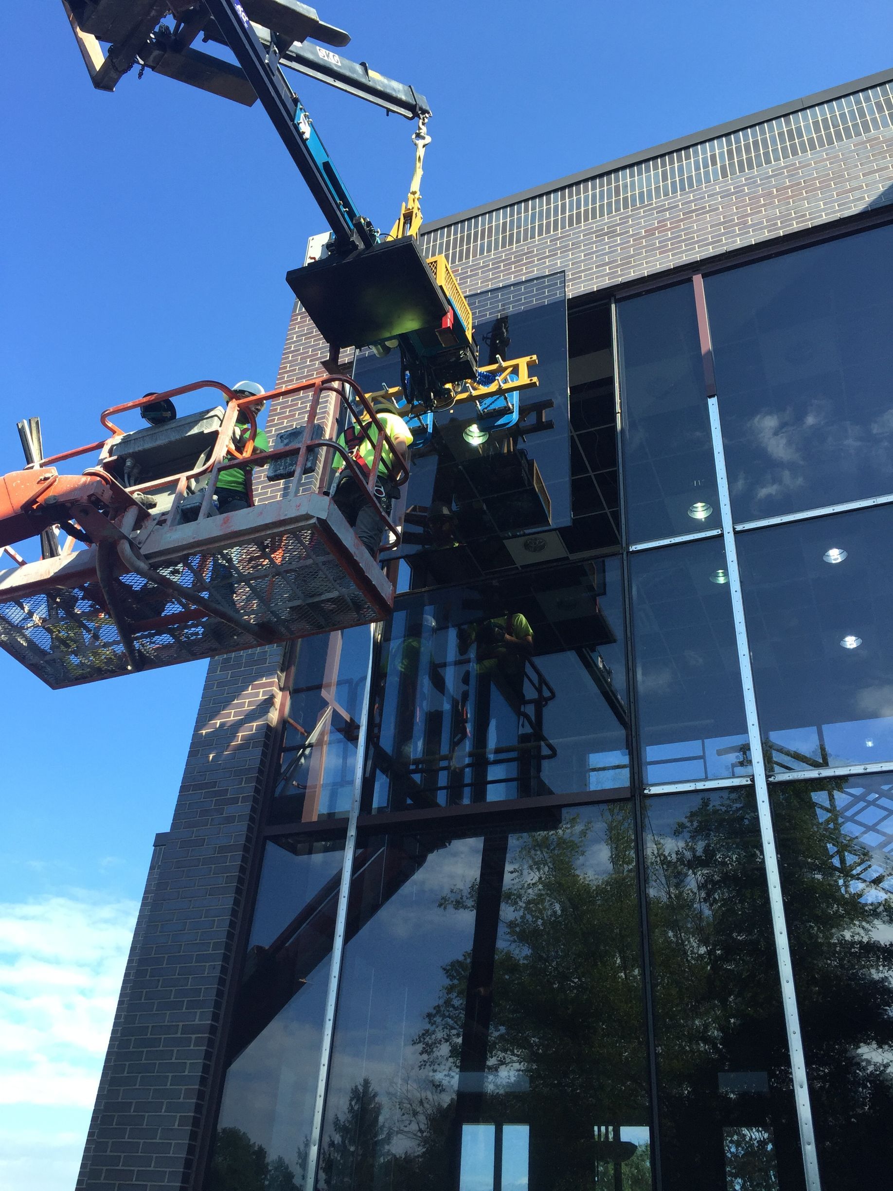 A crane is being used to remove a window from a building