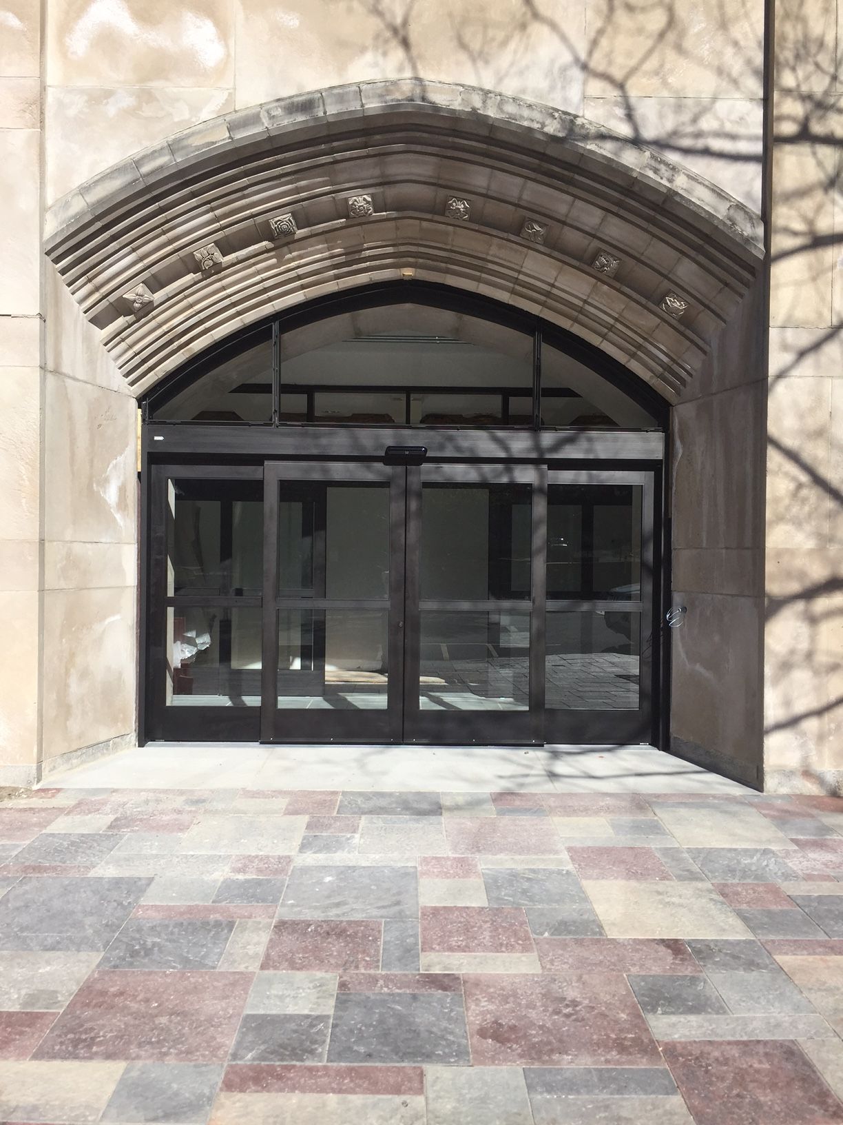 A building with a large archway and sliding glass doors.