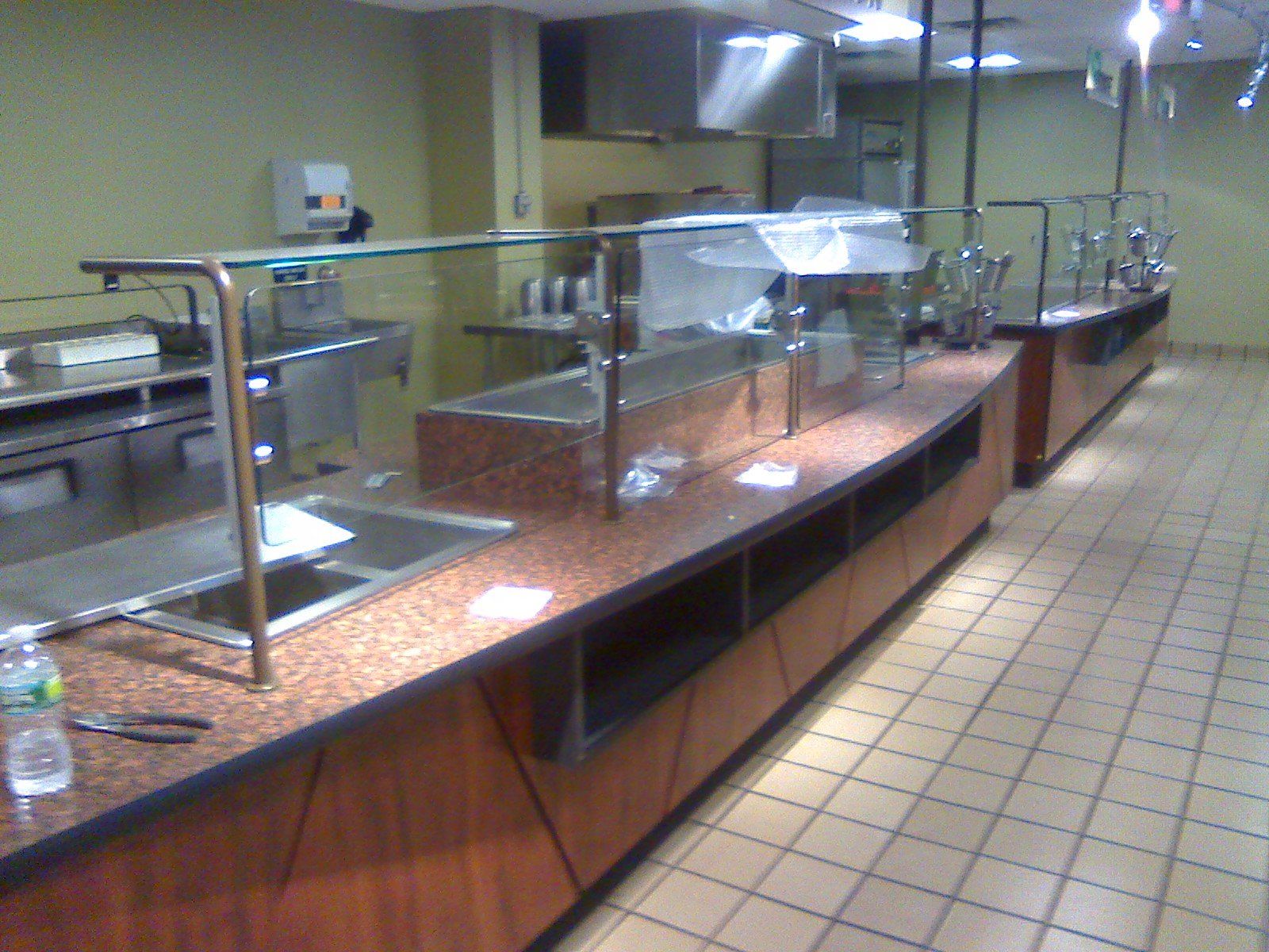 A buffet line with a bottle of water on the counter