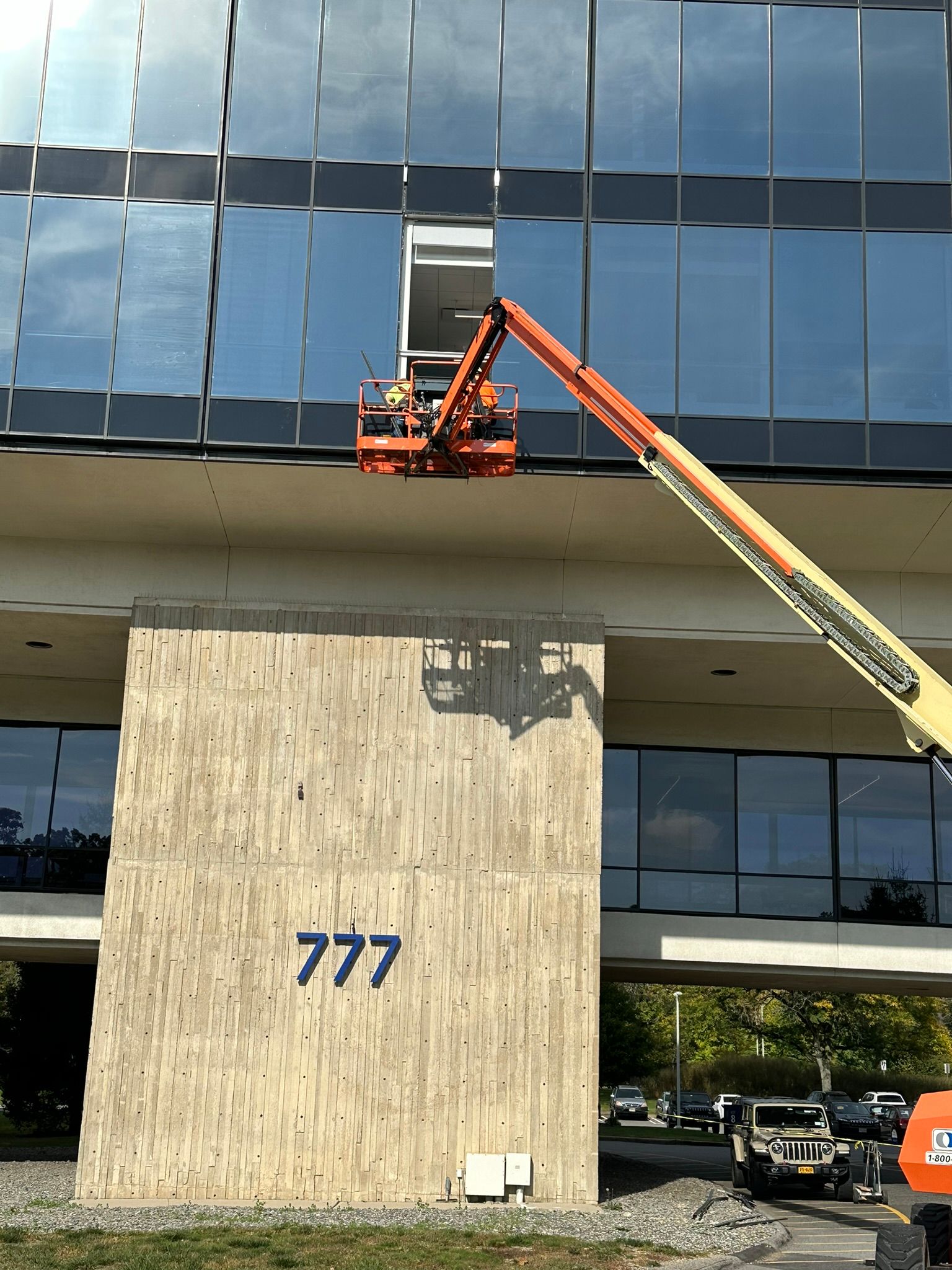 A crane is cleaning the windows of a large building.