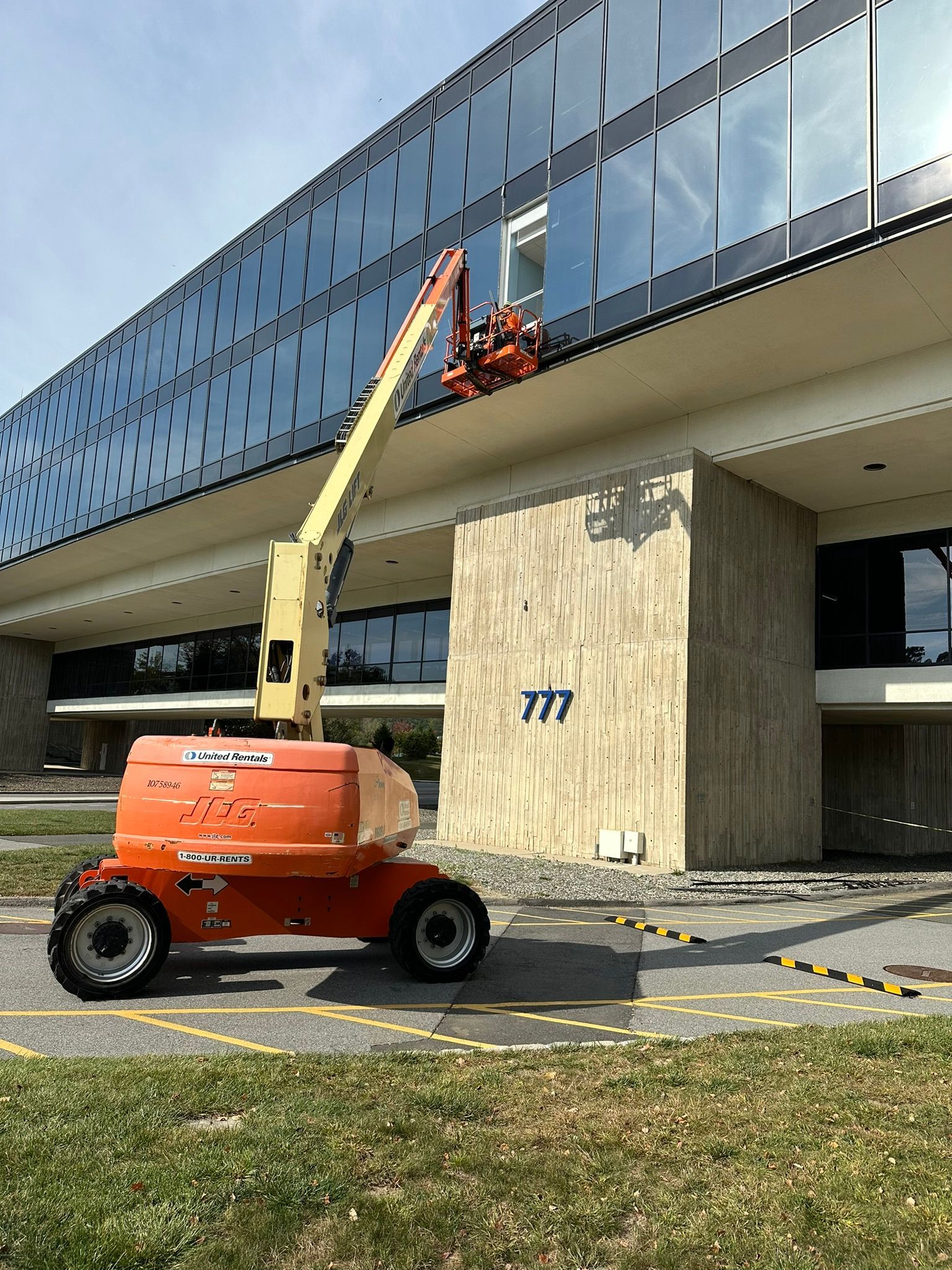 A crane is cleaning the windows of a large building.