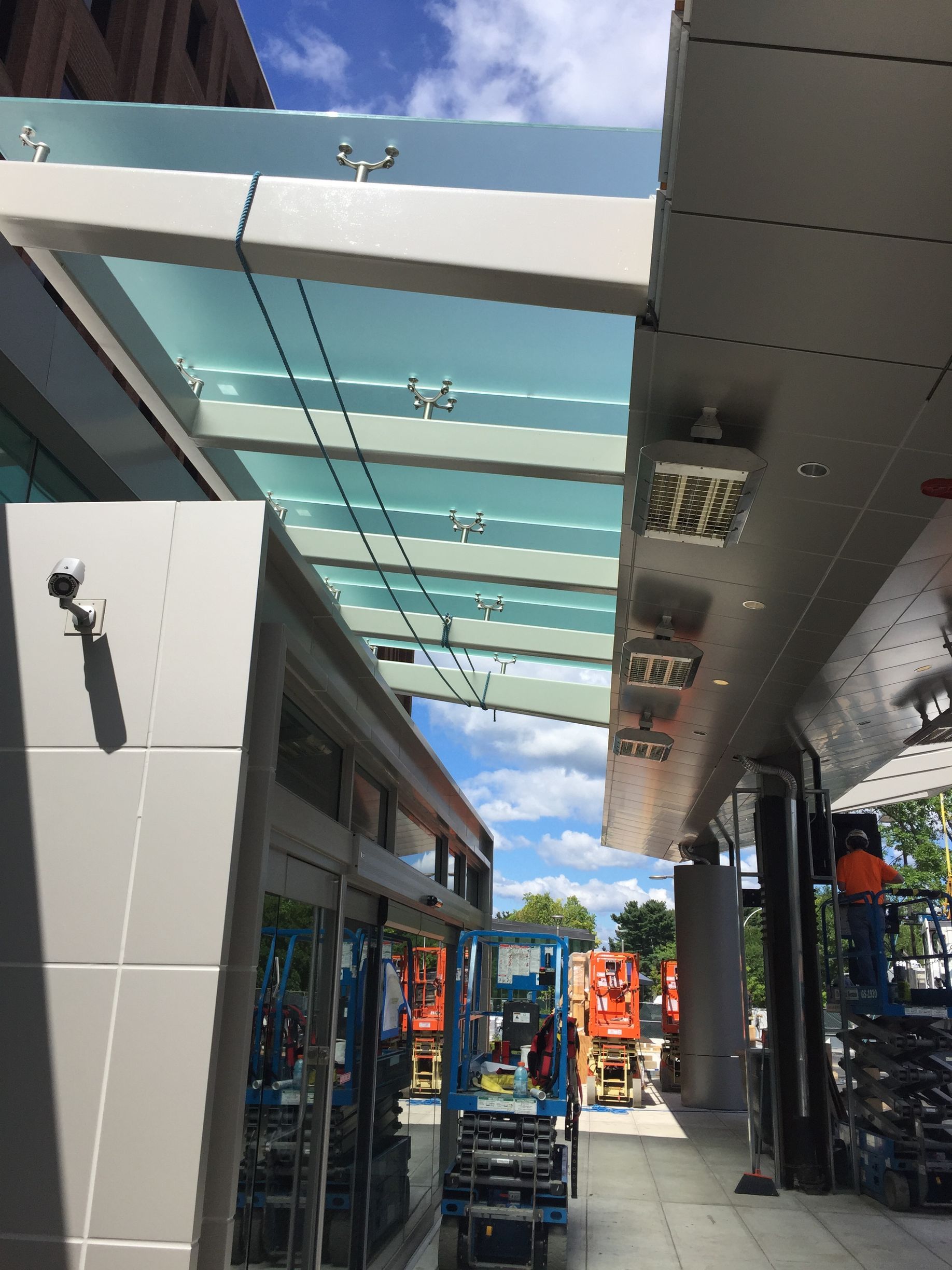 A glass canopy is being built on the side of a building.
