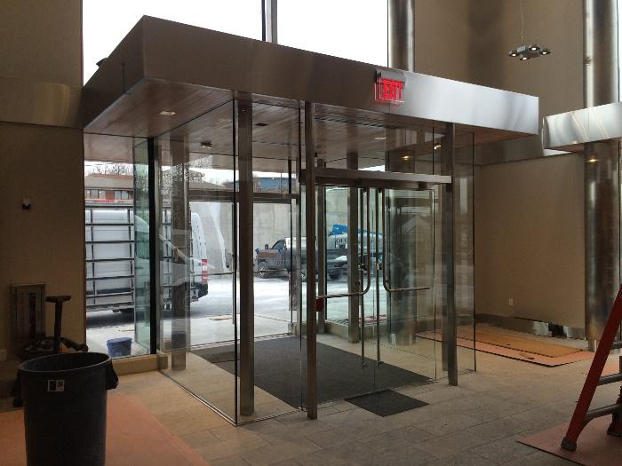 A stainless steel entrance to a building with a red exit sign