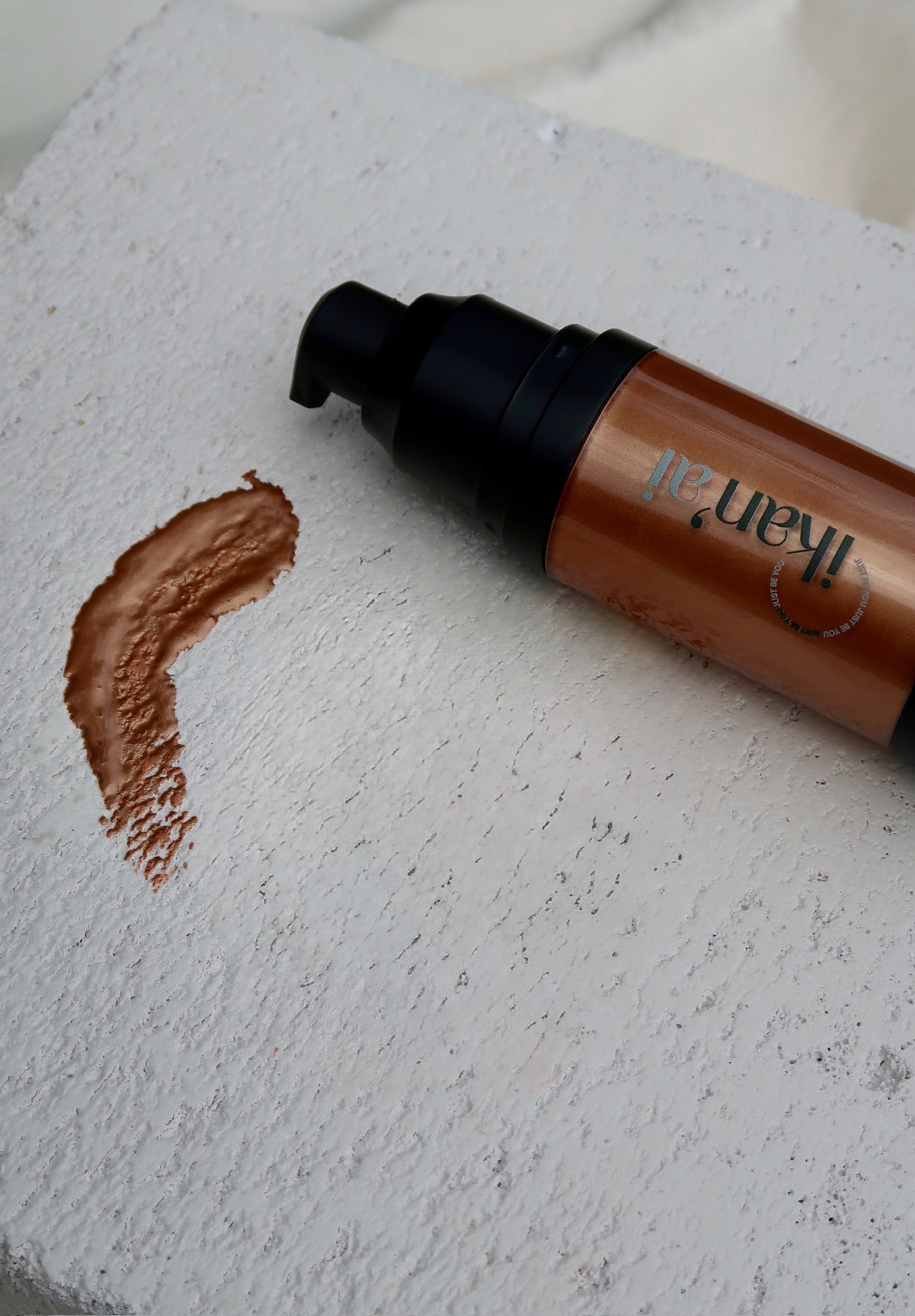 Brown makeup product and swatch on a white surface; product has a black pump — Ikan'ai In Bowral, NSW