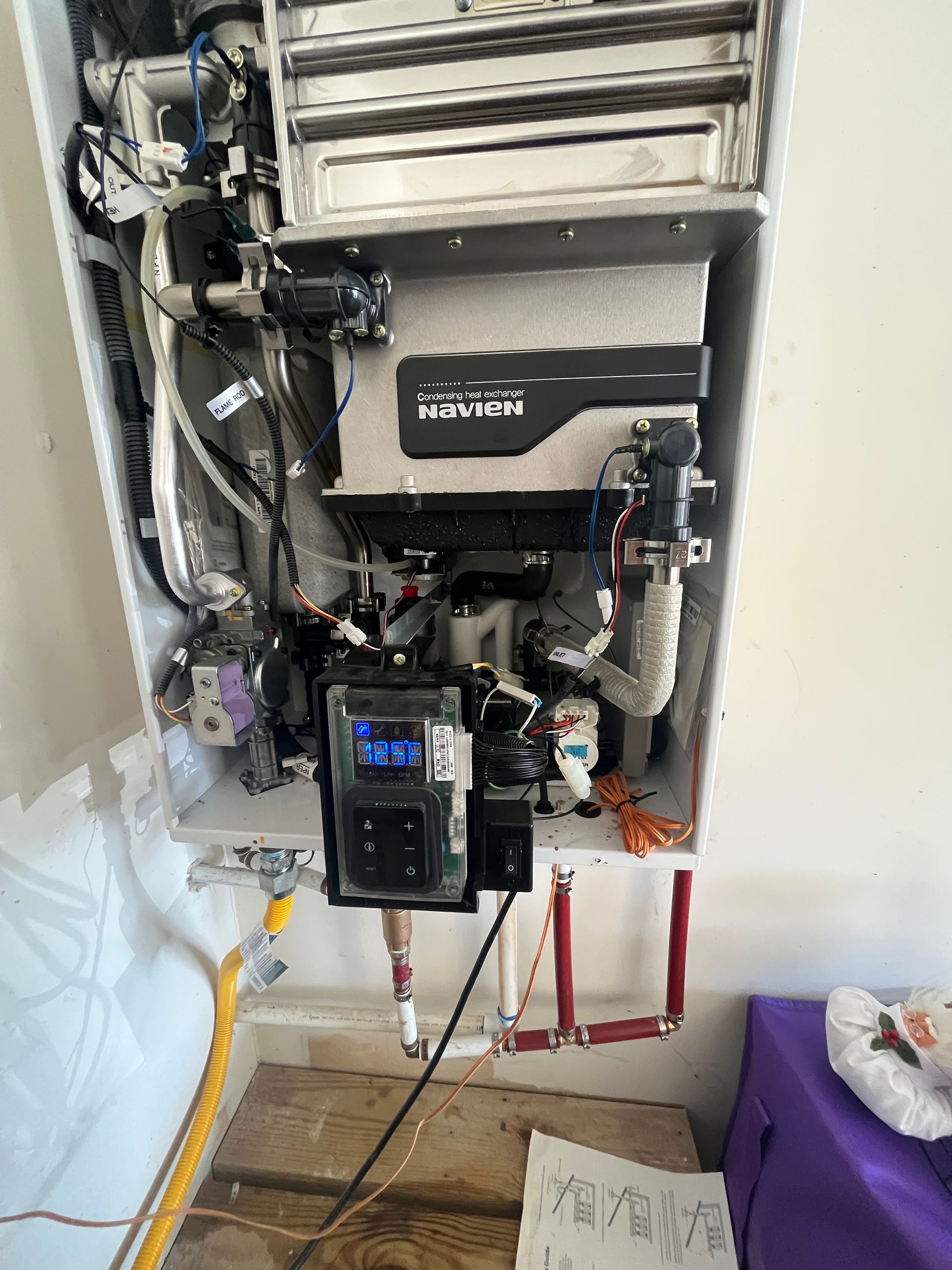 A water heater is being repaired in a bathroom.