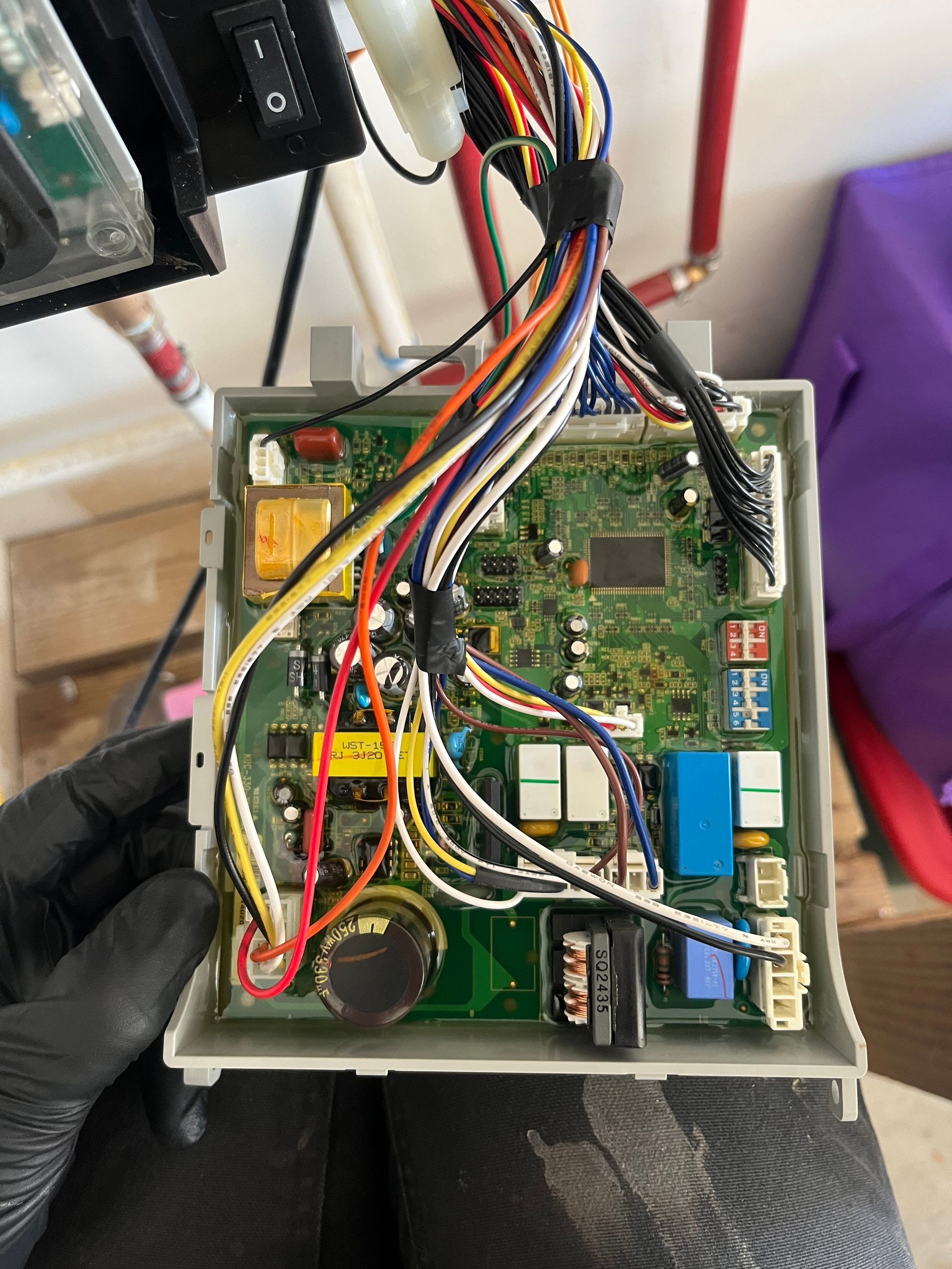 A person is holding a motherboard with a lot of wires on it