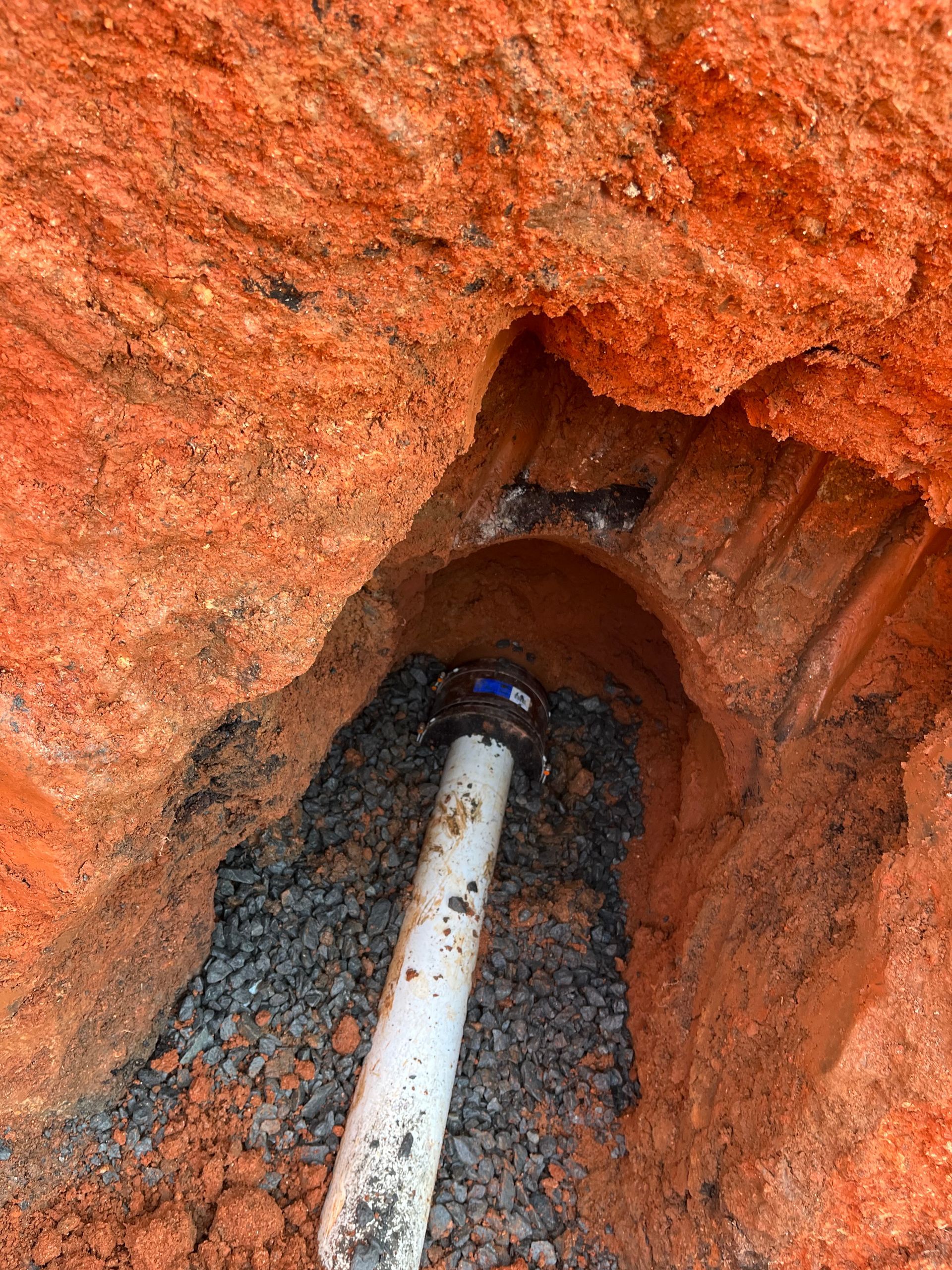 A white pipe is sitting in a hole in the ground.