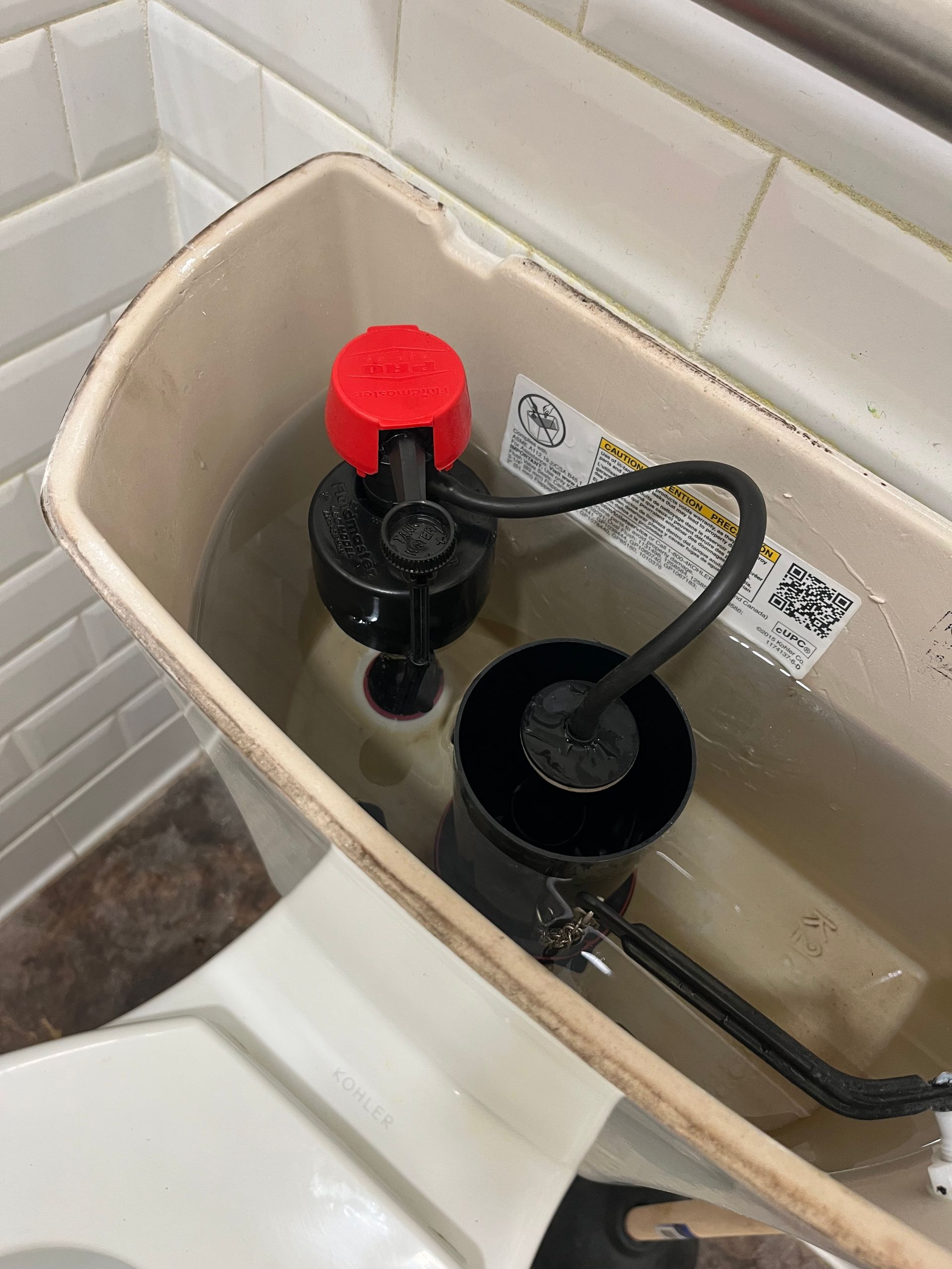 A toilet with a red cap on top of it